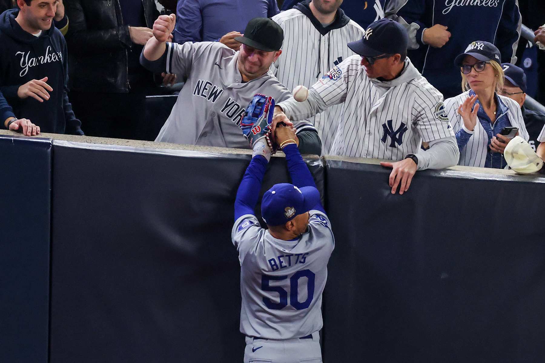 NEW YORK, NEW YORK - OCTOBER 29:  Fans interfere with Mookie Betts #50 of the Los Angeles Dodgers as he attempts to catch a fly ball in foul territory during the first inning of Game Four of the 2024 World Series against the New York Yankees at Yankee Stadium on October 29, 2024 in the Bronx borough of New York City. The play resulted in an out. (Photo by Al Bello/Getty Images)