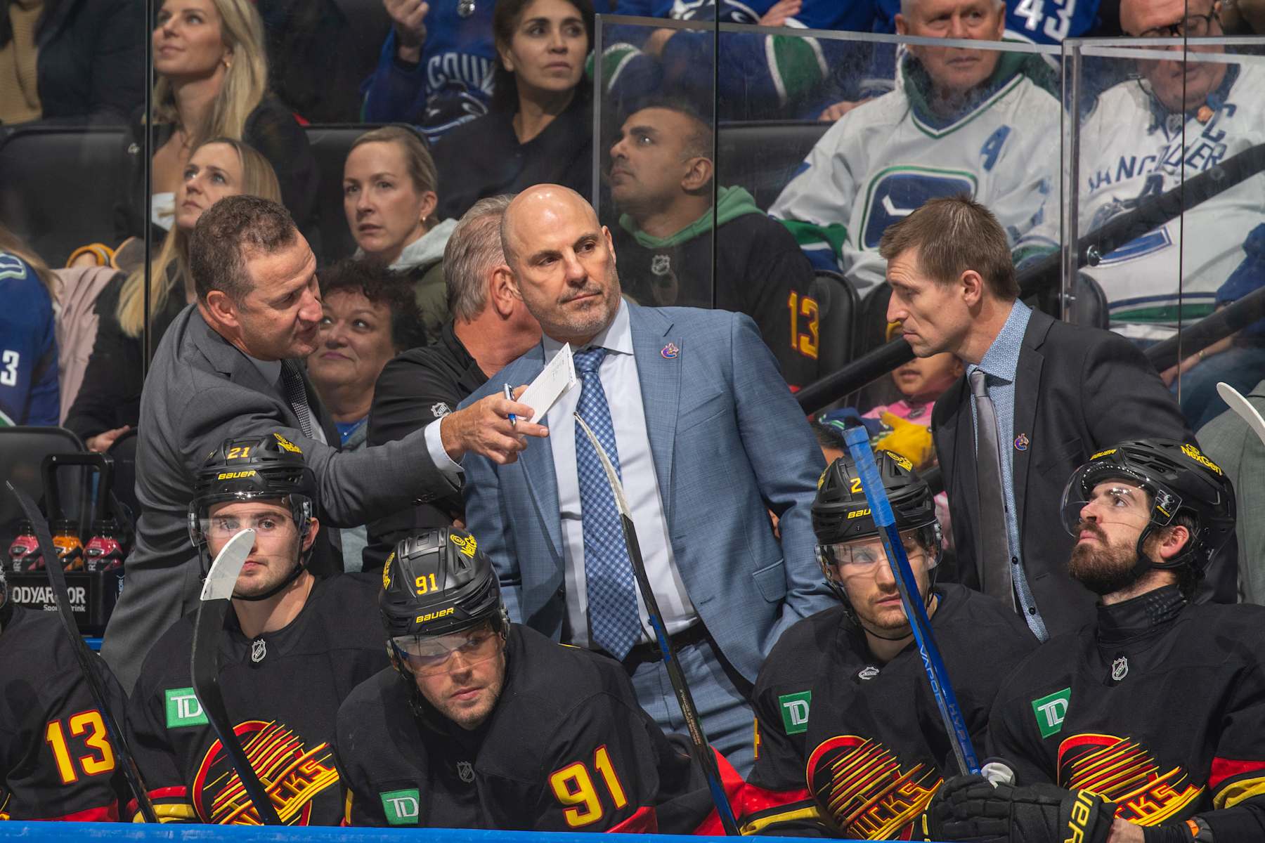 VANCOUVER, CANADA - OCTOBER 28: Head coach Rick Tocchet of the Vancouver Canucks and assistant coach Adam Foote of the Vancouver Canucks during the second period of their NHL game against the Carolina Hurricanes at Rogers Arena on October 28, 2024 in Vancouver, British Columbia, Canada. (Photo by Jeff Vinnick/NHLI via Getty Images)
