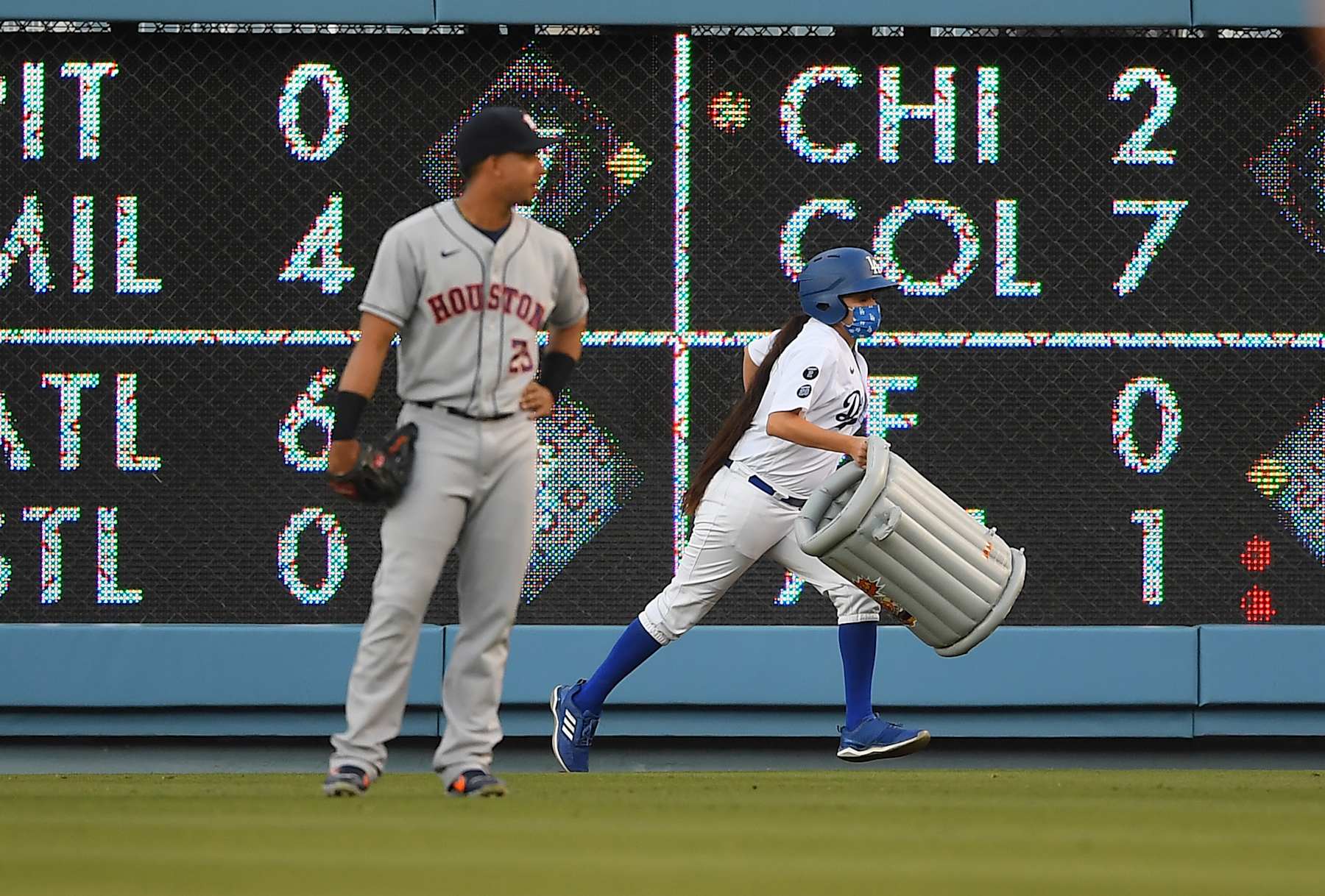 LOS ANGELES, CA - AUGUST 03: Michael Brantley #23 of the Houston Astros watches as a bat girl removes an inflatable trash can that was thrown on to the field in the first inning against the Los Angeles Dodgers at Dodger Stadium on August 3, 2021 in Los Angeles, California. (Photo by Jayne Kamin-Oncea/Getty Images)