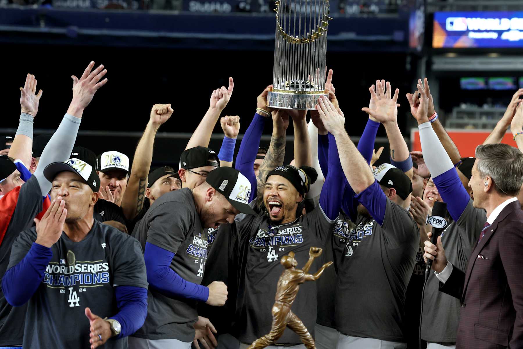 BRONX, NEW YORK - OCTOBER 30, 2024: From left to right: Dodgers manager Dave Roberts, Dodgers first base Freddie Freeman, Dodgers shortstop Mookie Betts, Dodgers third base Max Muncy and the rest of the players with the World Series trophy after the team's victory over the New York Yankees. Game 5 of the World Series against the Yankees at Yankees Stadium in New York City Wednesday, October 30 2024. (Robert Gauthier/Los Angeles Times via Getty Images)
