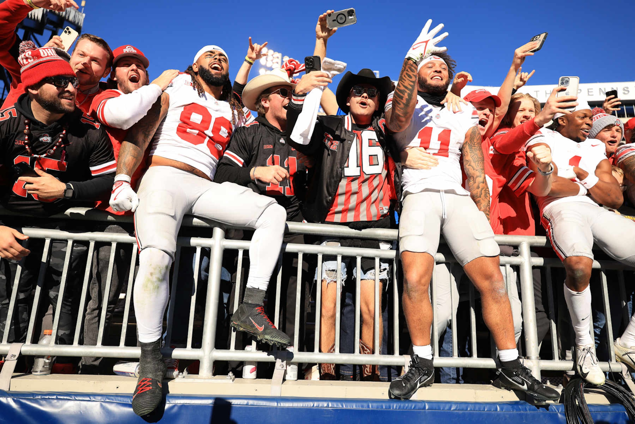 STATE COLLEGE, PENNSYLVANIA - NOVEMBER 02: Gee Scott Jr. #88, Brandon Inniss #11, and Quinshon Judkins #1 of the Ohio State Buckeyes celebrate with fans after defeating the Penn State Nittany Lions 20-13 at Beaver Stadium on November 02, 2024 in State College, Pennsylvania. (Photo by Scott Taetsch/Getty Images)