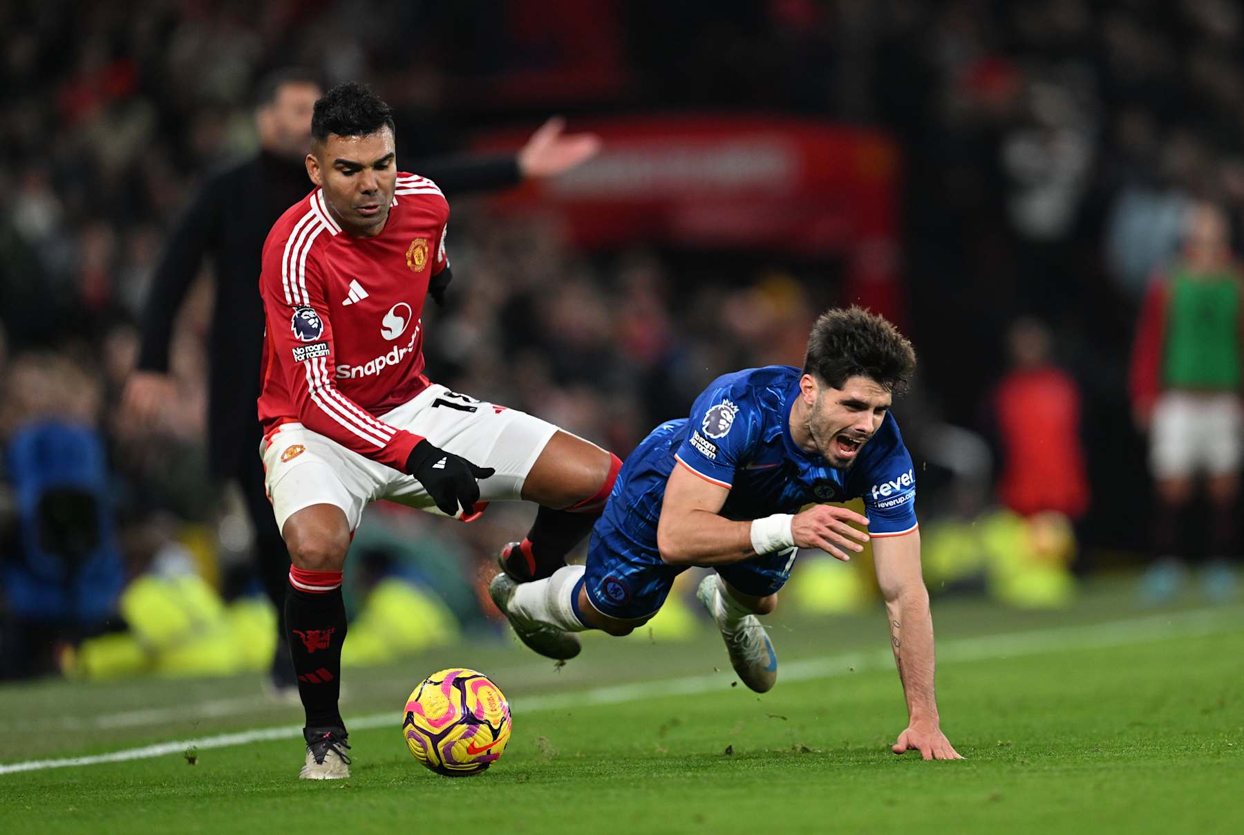 MANCHESTER, ENGLAND - NOVEMBER 03: Pedro Neto of Chelsea is challenged by Casemiro of Manchester United during the Premier League match between Manchester United FC and Chelsea FC at Old Trafford on November 03, 2024 in Manchester, England. (Photo by Darren Walsh/Chelsea FC via Getty Images)
