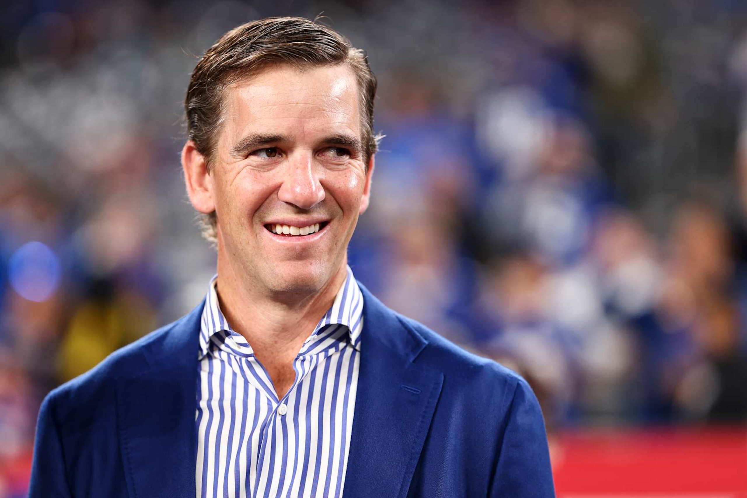 EAST RUTHERFORD, NEW JERSEY - OCTOBER 13: Former New York Giants quarterback Eli Manning smiles on the field prior to an NFL game between the New York Giants and the Cincinnati Bengals at MetLife Stadium on October 13, 2024 in East Rutherford, New Jersey. (Photo by Kevin Sabitus/Getty Images)