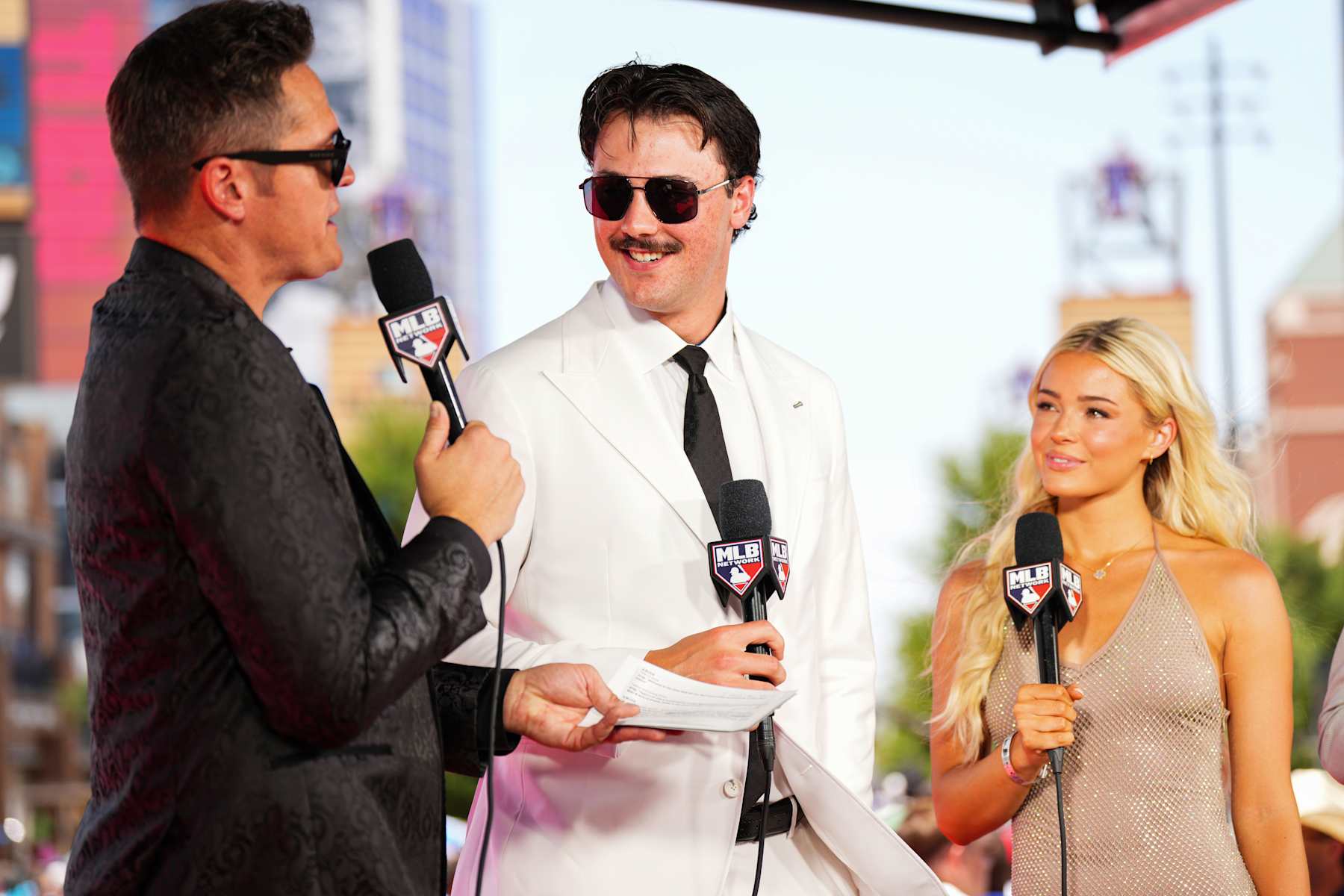 ARLINGTON, TX - JULY 16: Paul Skenes #30 of the Pittsburgh Pirates and Livvy Dunne talk with MLB Network hosts during the 2024 All-Star Red Carpet Show presented by Frutitas Agua Fresca at Globe Life Field North Plaza on Tuesday, July 16, 2024 in Arlington, Texas. (Photo by Cooper Neill/MLB Photos via Getty Images)