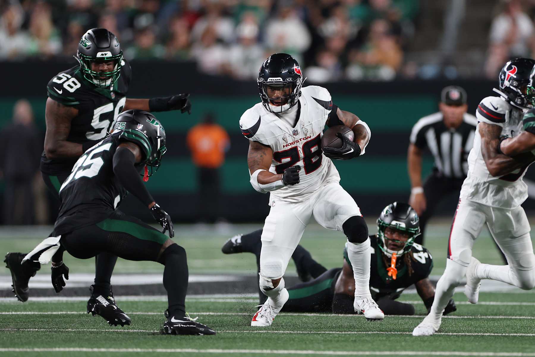 EAST RUTHERFORD, NEW JERSEY - OCTOBER 31: Joe Mixon #28 of the Houston Texans runs the ball against Jalen Mills #35 of the New York Jets during the first quarter at MetLife Stadium on October 31, 2024 in East Rutherford, New Jersey. (Photo by Luke Hales/Getty Images)