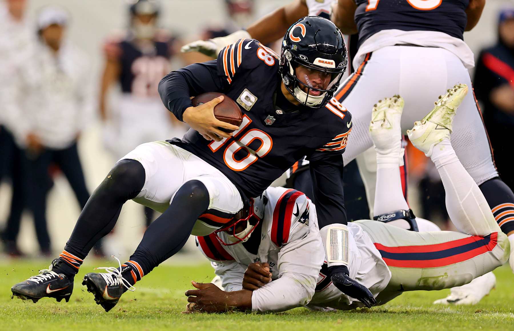 CHICAGO, ILLINOIS - NOVEMBER 10: Caleb Williams #18 of the Chicago Bears is sacked by Keion White #99 of the New England Patriots during the fourth quarter at Soldier Field on November 10, 2024 in Chicago, Illinois. (Photo by Michael Reaves/Getty Images)