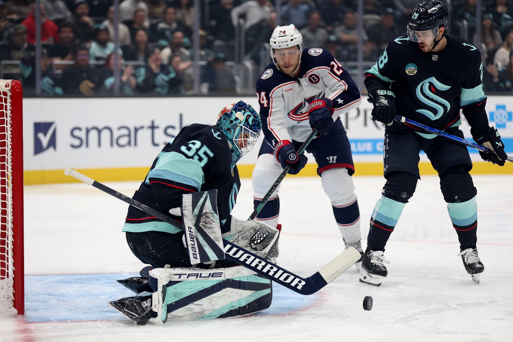 SEATTLE, WASHINGTON - NOVEMBER 12: Joey Daccord #35 of the Seattle Kraken makes a save next to Mathieu Olivier #24 of the Columbus Blue Jackets during the first period at Climate Pledge Arena on November 12, 2024 in Seattle, Washington. (Photo by Steph Chambers/Getty Images)