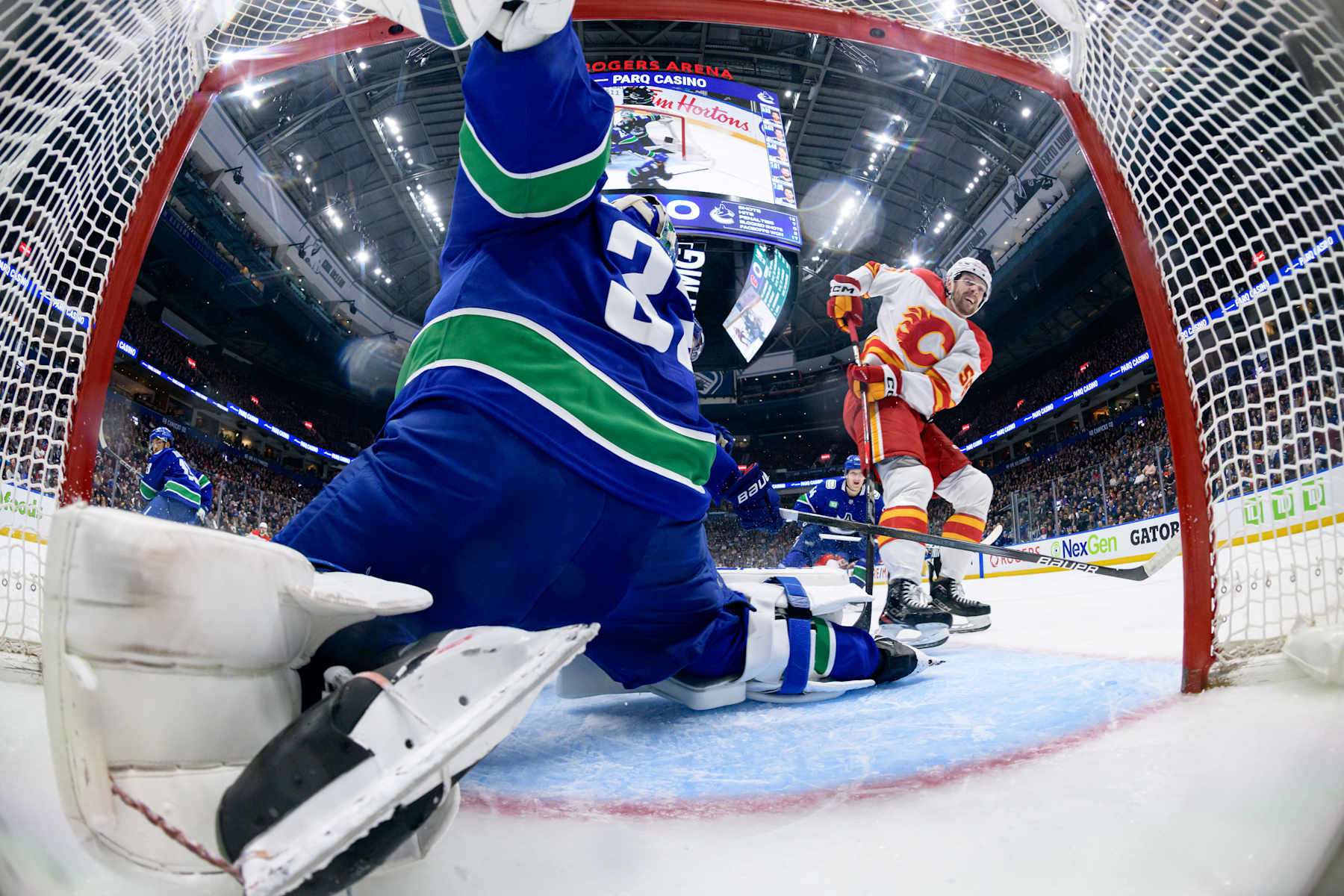 VANCOUVER, CANADA - NOVEMBER 12: Justin Kirkland #58 of the Calgary Flames scores a goal on Kevin Lankinen #32 of the Vancouver Canucks during the second period at Rogers Arena on November 12, 2024 in Vancouver, British Columbia, Canada. (Photo by Derek Cain/Getty Images)