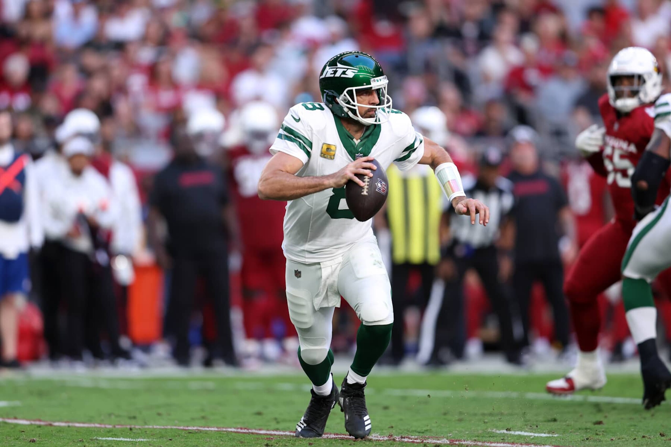 GLENDALE, ARIZONA - NOVEMBER 10: Quarterback Aaron Rodgers #8 of the New York Jets scrambles during the game against the Arizona Cardinals at State Farm Stadium on November 10, 2024 in Glendale, Arizona. The Cardinals defeated the Jets 31-6. (Photo by Chris Coduto/Getty Images)