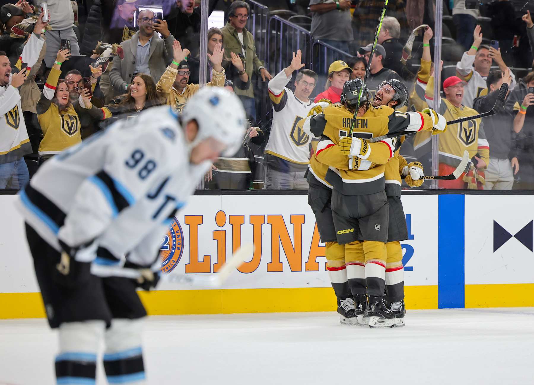 LAS VEGAS, NEVADA - NOVEMBER 02: Mikhail Sergachev #98 of the Utah Hockey Club skates off the ice as Noah Hanifin #15 and Mark Stone (R) #61 of the Vegas Golden Knights celebrate Brett Howden #21 after he scored a goal in overtime against the Hockey Club to win the game 4-3 at T-Mobile Arena on November 02, 2024 in Las Vegas, Nevada. (Photo by Ethan Miller/Getty Images)