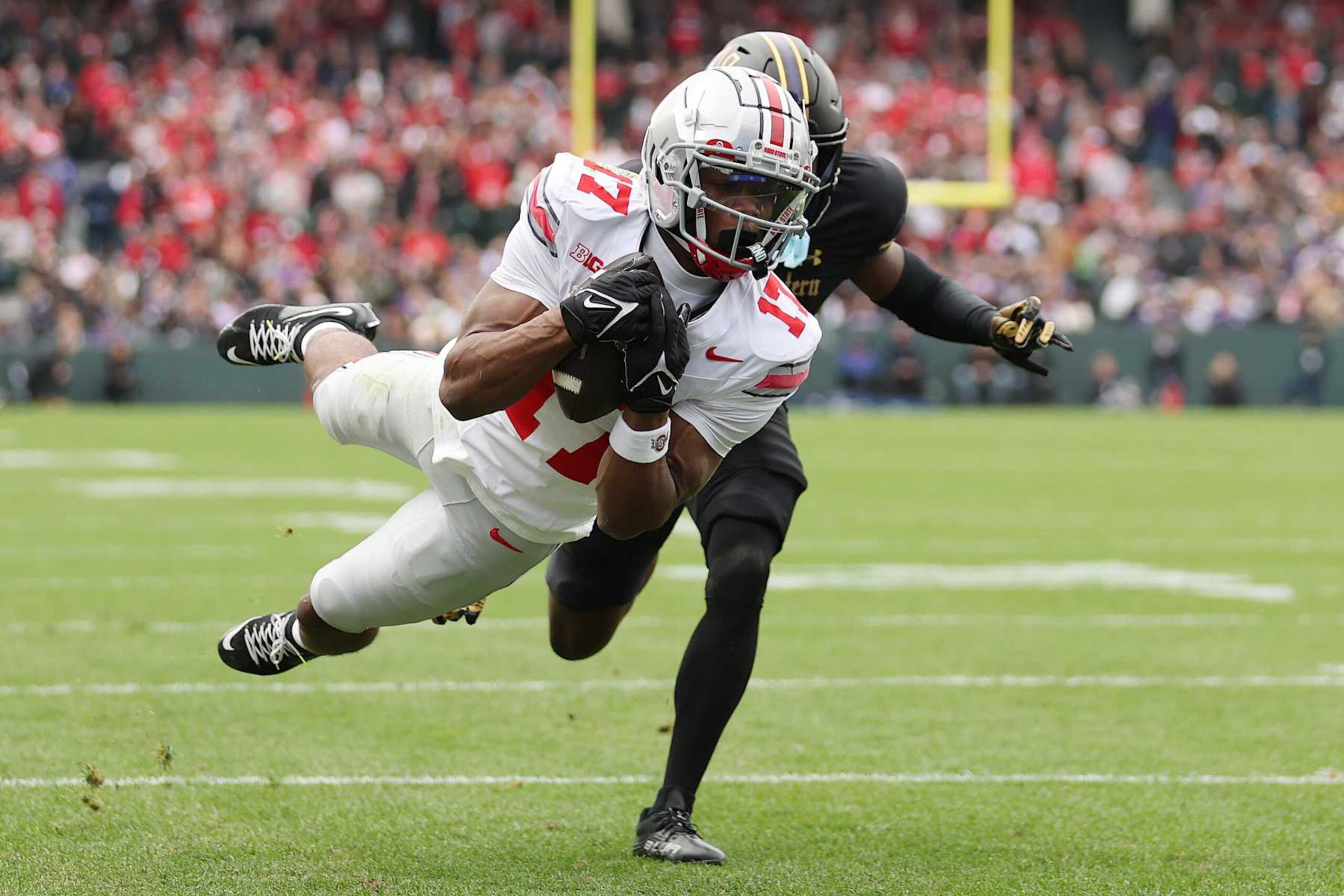 CHICAGO, ILLINOIS - NOVEMBER 16: Carnell Tate #17 of the Ohio State Buckeyes catches a touchdown pass against Josh Fussell #13 of the Northwestern Wildcats during the first half at Wrigley Field on November 16, 2024 in Chicago, Illinois. (Photo by Michael Reaves/Getty Images) CHICAGO, ILLINOIS - NOVEMBER 16: Carnell Tate #17 of the Ohio State Buckeyes catches a touchdown pass against Josh Fussell #13 of the Northwestern Wildcats during the first half at Wrigley Field on November 16, 2024 in Chicago, Illinois. (Photo by Michael Reaves/Getty Images)
