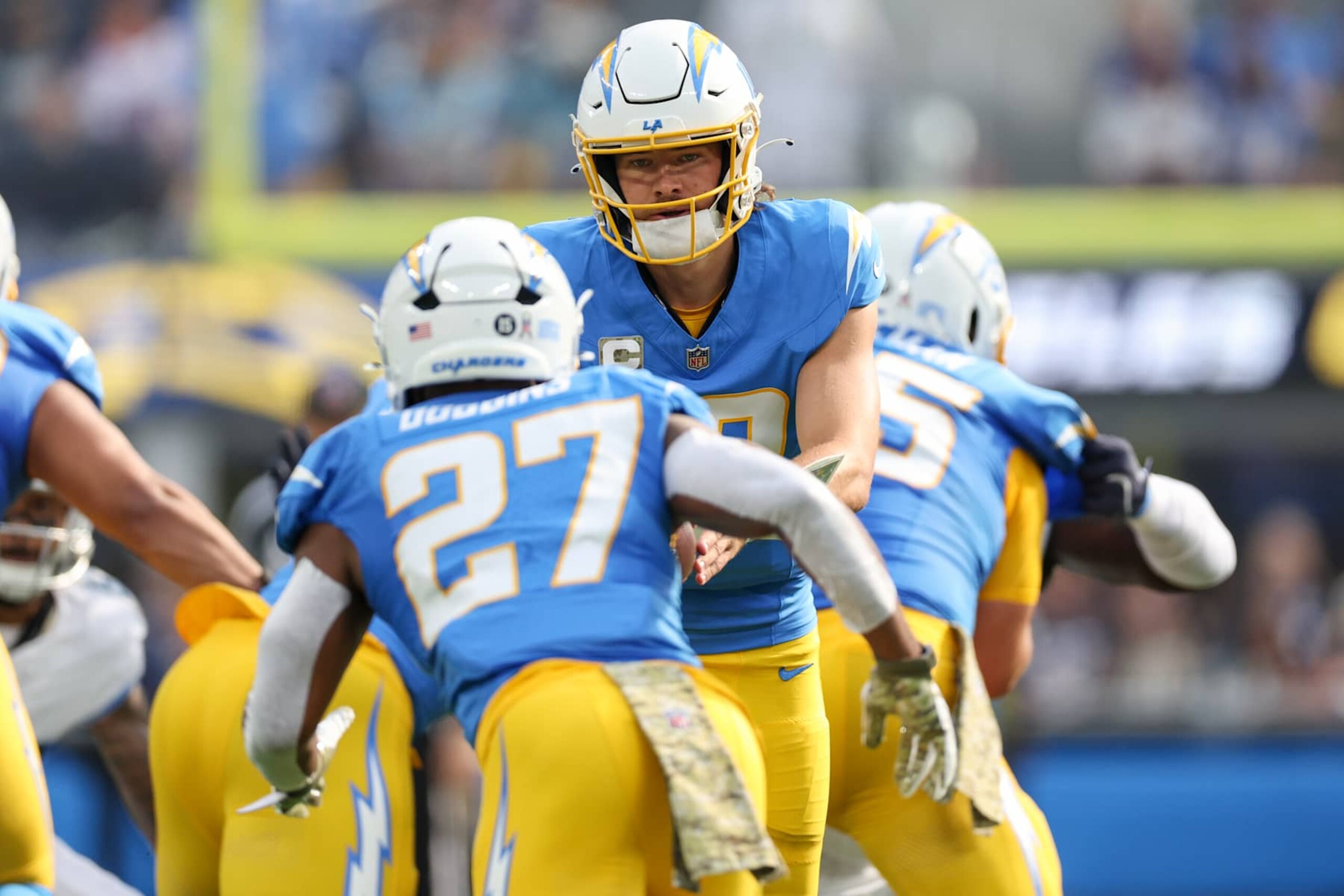INGLEWOOD, CALIFORNIA - NOVEMBER 10: Justin Herbert #10 of the Los Angeles Chargers hands the ball off to J.K. Dobbins #27 in the first quarter of a game against the Tennessee Titans at SoFi Stadium on November 10, 2024 in Inglewood, California. (Photo by Harry How/Getty Images)