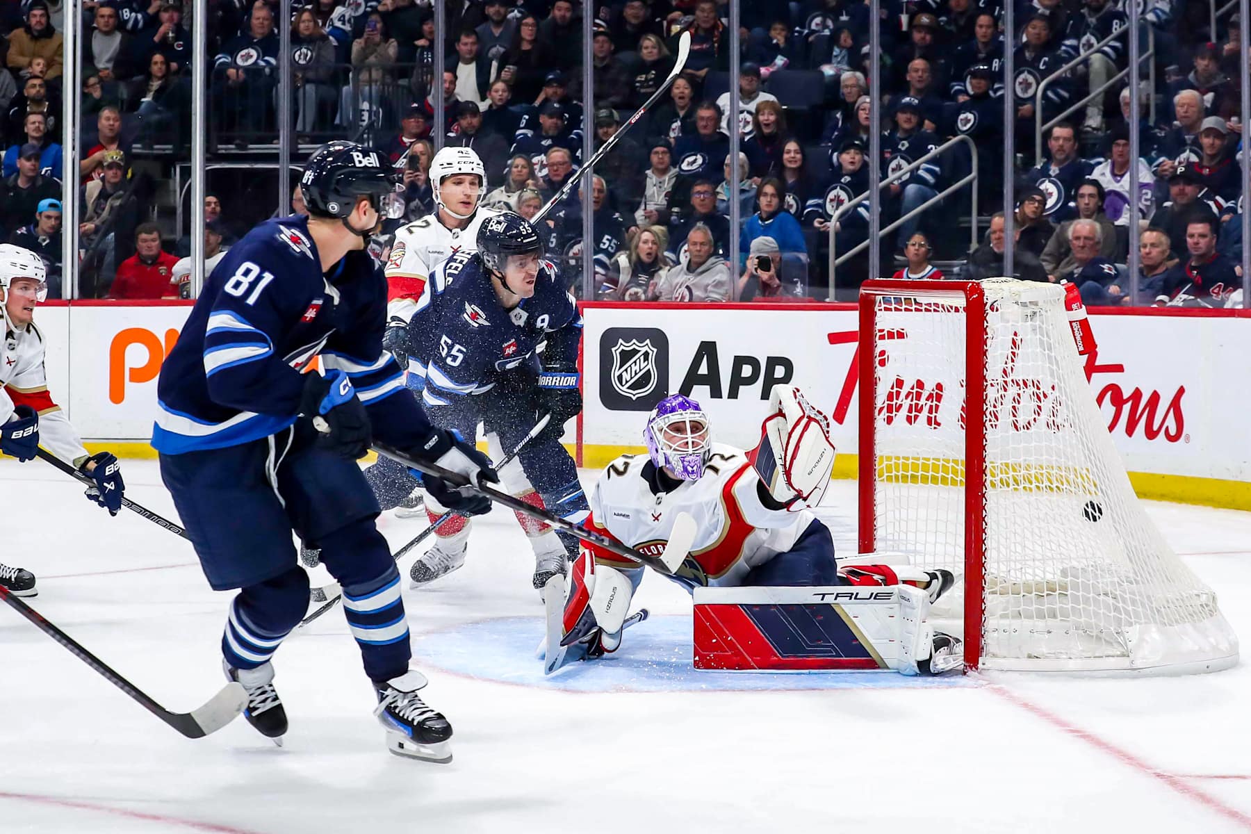 WINNIPEG, CANADA - NOVEMBER 19: Kyle Connor #81 and Mark Scheifele #55 of the Winnipeg Jets watch as the puck gets to the back of the net behind goaltender Sergei Bobrovsky #72 of the Florida Panthers for a first period goal at the Canada Life Centre on November 19, 2024 in Winnipeg, Manitoba, Canada. (Photo by Darcy Finley/NHLI via Getty Images)