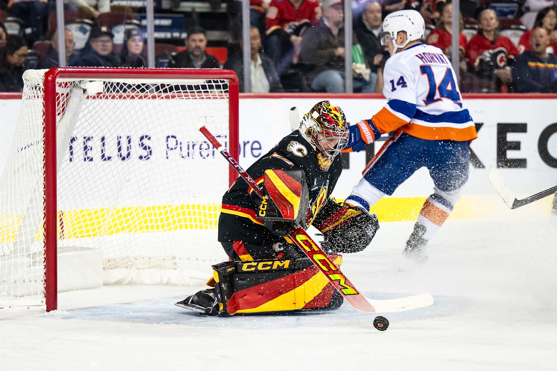 CALGARY, AB - NOVEMBER 19: Calgary Flames Goaltender Dustin Wolf (32) stops New York Islanders Center Bo Horvat (14) during the first period of an NHL game on November 19, 2024, at the Scotiabank Saddledome in Calgary, AB. (Photo by Brett Holmes/Icon Sportswire via Getty Images)