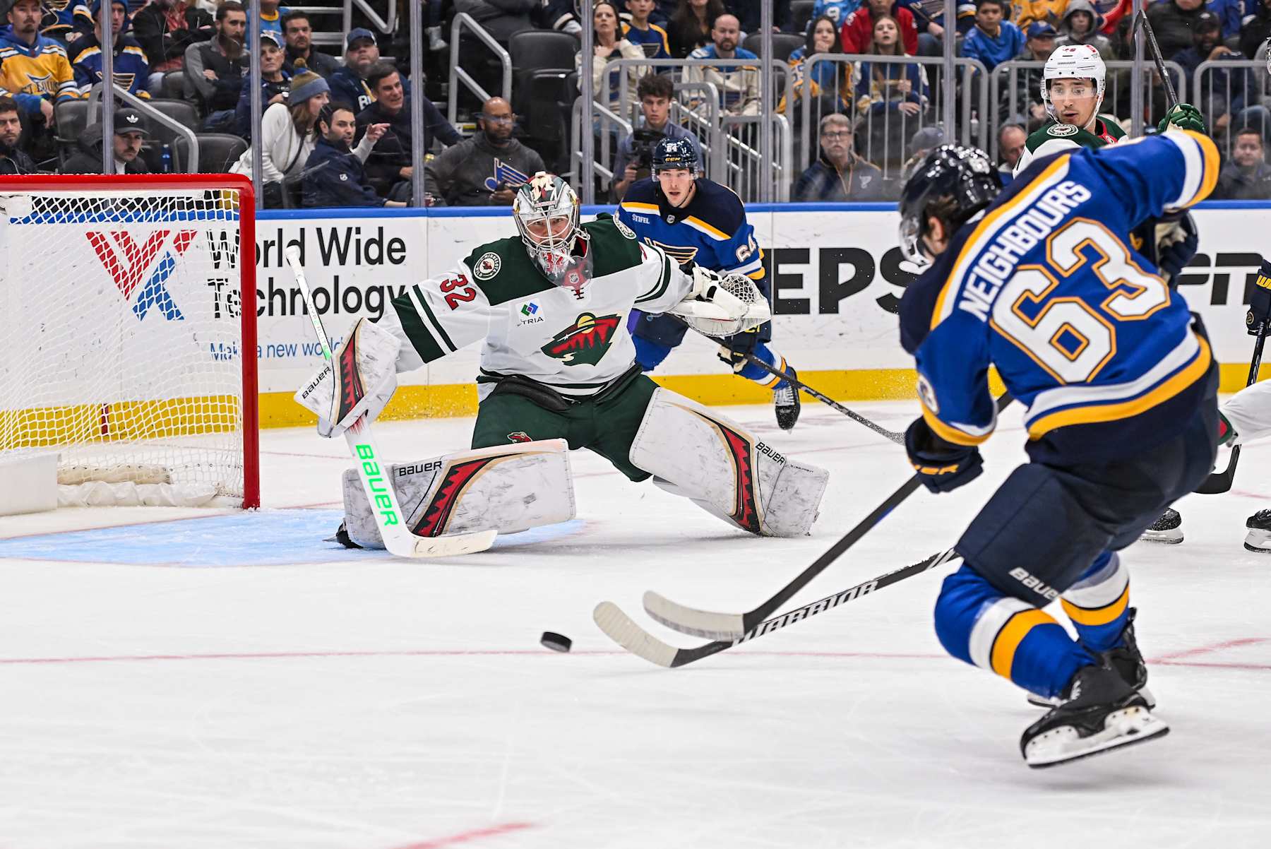 ST. LOUIS, MO - NOVEMBER 19: Minnesota Wild goaltender Filip Gustavsson (32) slides over to try and stop the shot by St. Louis Blues left wing Jake Neighbours (63) during a regular season game where the St. Louis Blues hosted the Minnesota Wild on Tuesday November 19, 2024, at the Enterprise Center in St. Louis MO (Photo by Rick Ulreich/Icon Sportswire via Getty Images)