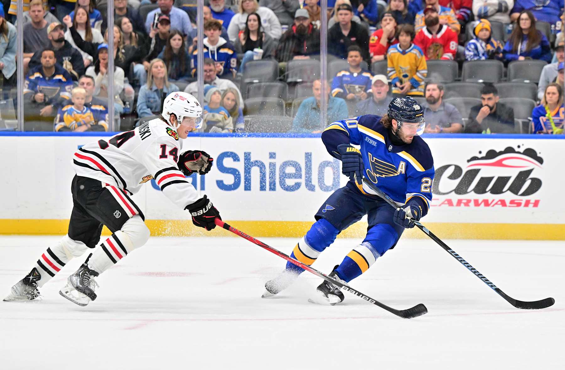 ST. LOUIS, MO - SEPTEMBER 28: St. Louis Blues leftwing Brandon Saad (20) controls the puck with pressure from Chicago Blackhawks defenseman Kevin Korchinski (14) during a preseason NHL game between the Chicago Blackhawks and the St. Louis Blues, on September 28, 2024, at Enterprise Center, St. Louis, MO. (Photo by Keith Gillett/IconSportswire)