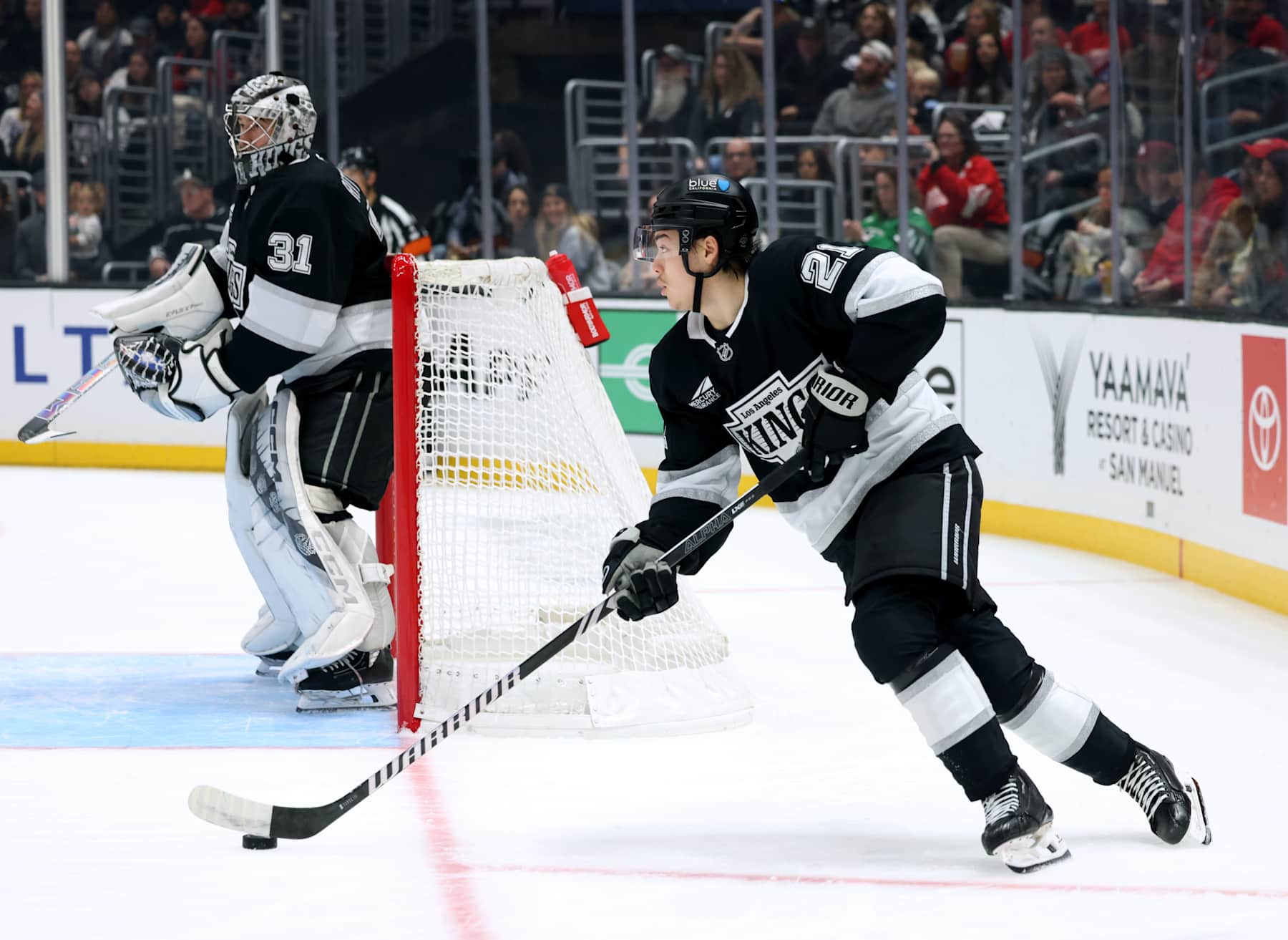 LOS ANGELES, CALIFORNIA - NOVEMBER 16: Jordan Spence #21 of the Los Angeles Kings leads a rush next to David Rittich #31 during a 4-1 win over the Detroit Red Wings at Crypto.com Arena on November 16, 2024 in Los Angeles, California. (Photo by Harry How/Getty Images)