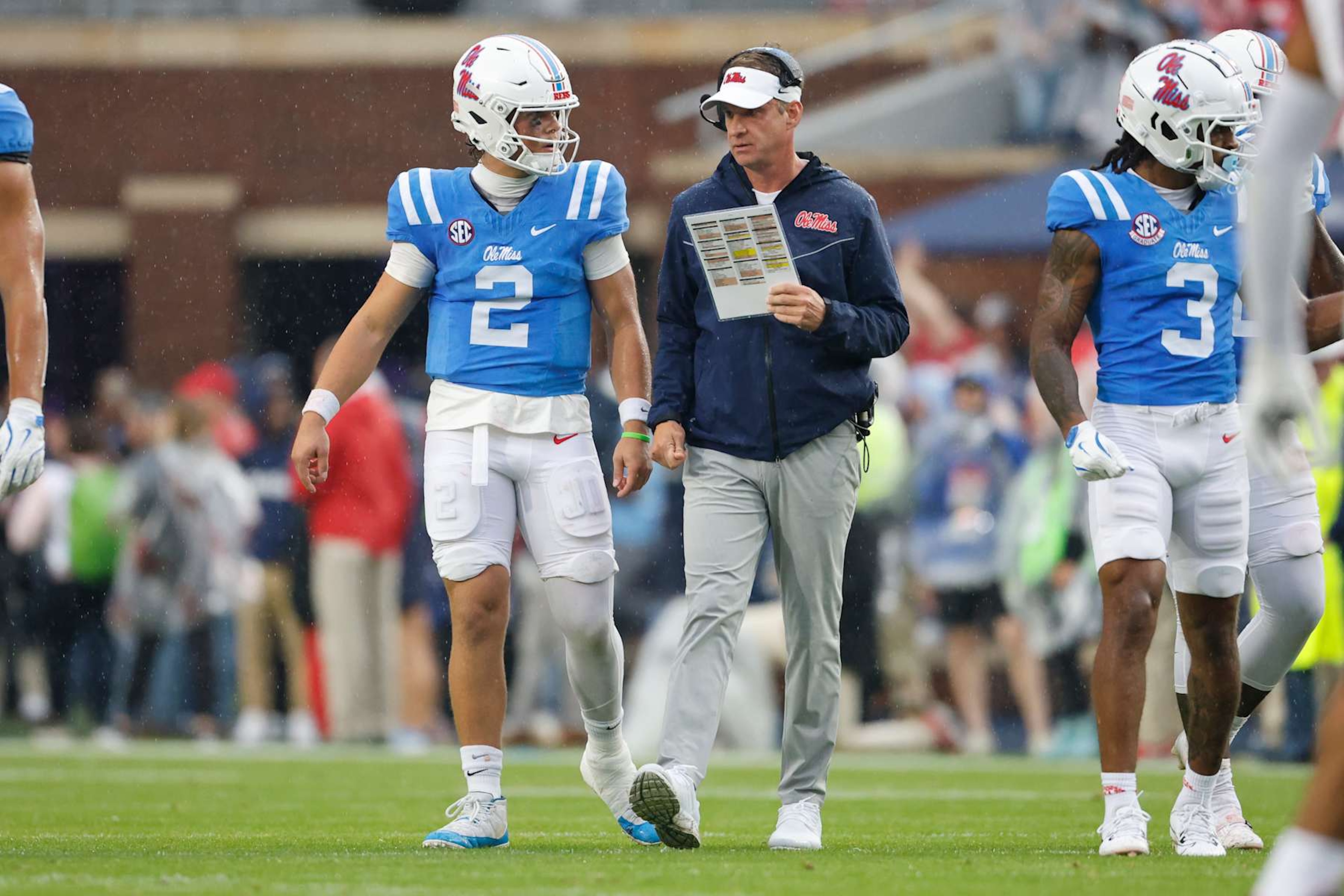OXFORD, MS - NOVEMBER 09: Mississippi Rebels quarterback Jaxson Dart (2) talks with Mississippi Rebels head coach Lane Kiffin during the college football game between Georgia Bulldogs and Ole Miss Rebels on November 9, 2024, at Vaught-Hemingway Stadium in Oxford, Mississippi. (Photo by Andy Altenburger/Icon Sportswire via Getty Images) OXFORD, MS - NOVEMBER 09: Mississippi Rebels quarterback Jaxson Dart (2) talks with Mississippi Rebels head coach Lane Kiffin during the college football game between Georgia Bulldogs and Ole Miss Rebels on November 9, 2024, at Vaught-Hemingway Stadium in Oxford, Mississippi. (Photo by Andy Altenburger/Icon Sportswire via Getty Images)