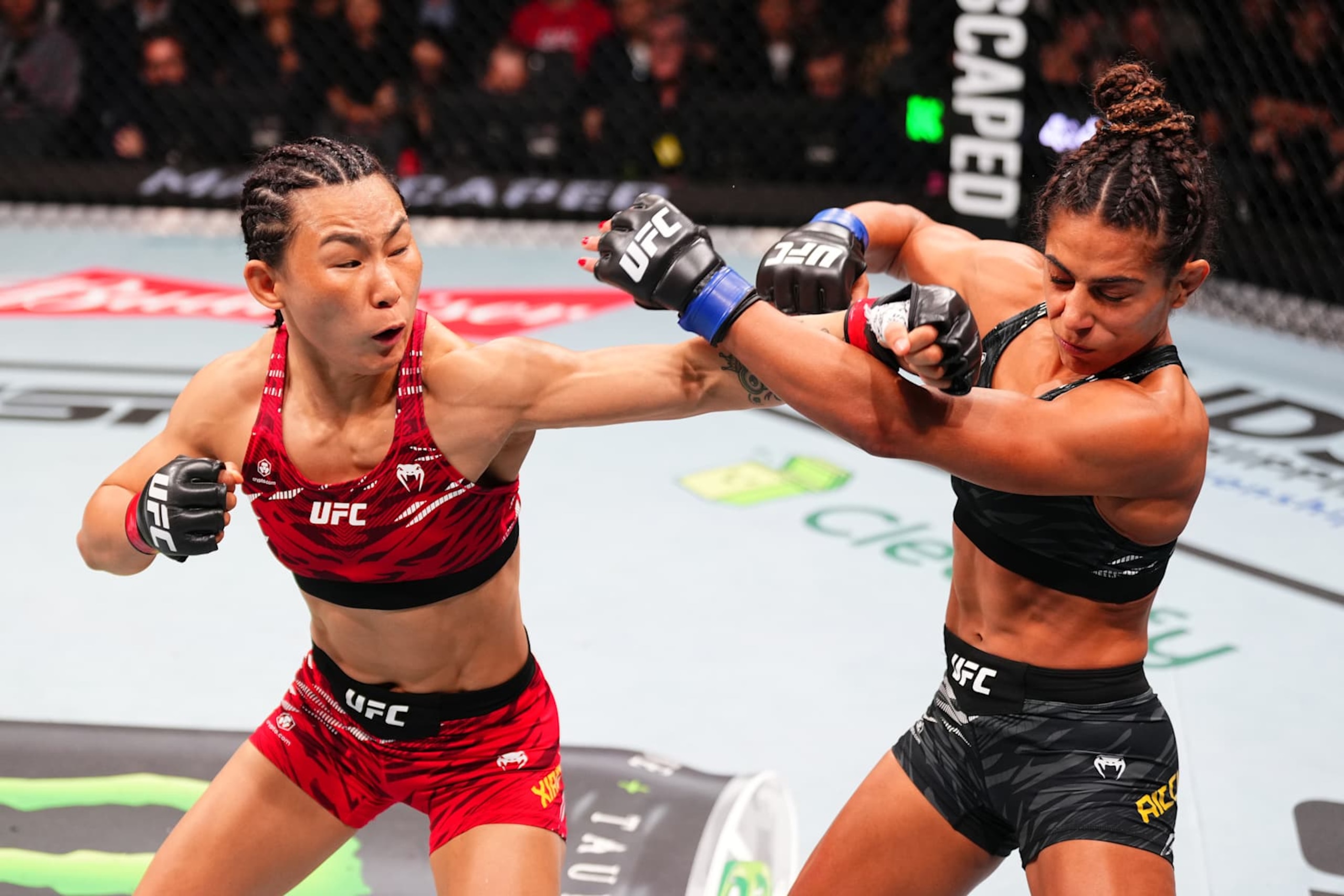 MACAU, CHINA - NOVEMBER 23:  (L-) Yan Xiaonan of China punches Tabatha Ricci of Brazil in their women's strawweight fight during the UFC Fight Night event at Galaxy Arena on November 23, 2024 in Macau, China. (Photo by Jeff Bottari/Zuffa LLC)