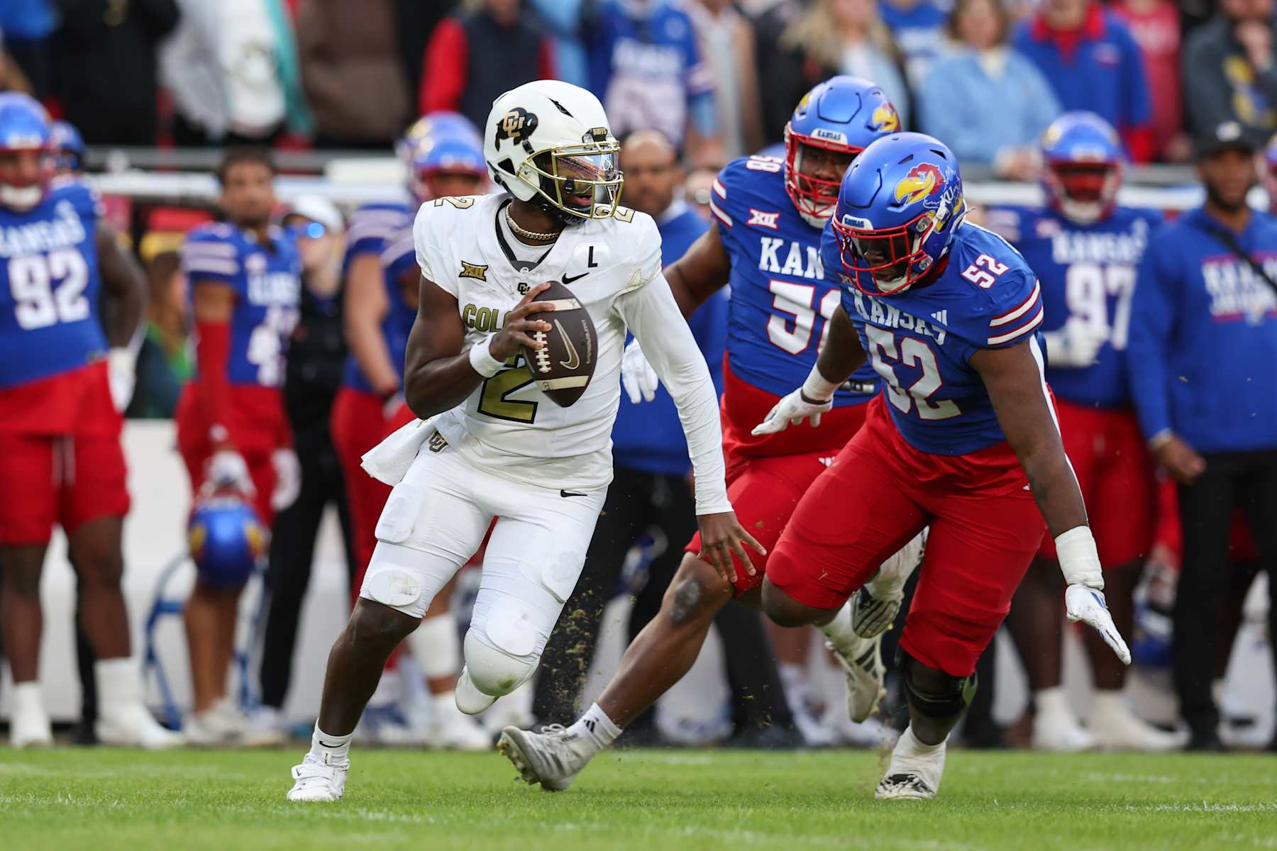 KANSAS CITY, MO - NOVEMBER 23: Colorado Buffaloes quarterback Shedeur Sanders (2) scrambles away from the pressure o fKansas Jayhawks defensive tackle D.J. Withers (52) in the second quarter of a Big 12 game between the Colorado Buffaloes and Kansas Jayhawks on November 23, 2024 at GEHA Field at Arrowhead Stadium in Kansas City, MO. (Photo by Scott Winters/Icon Sportswire via Getty Images)