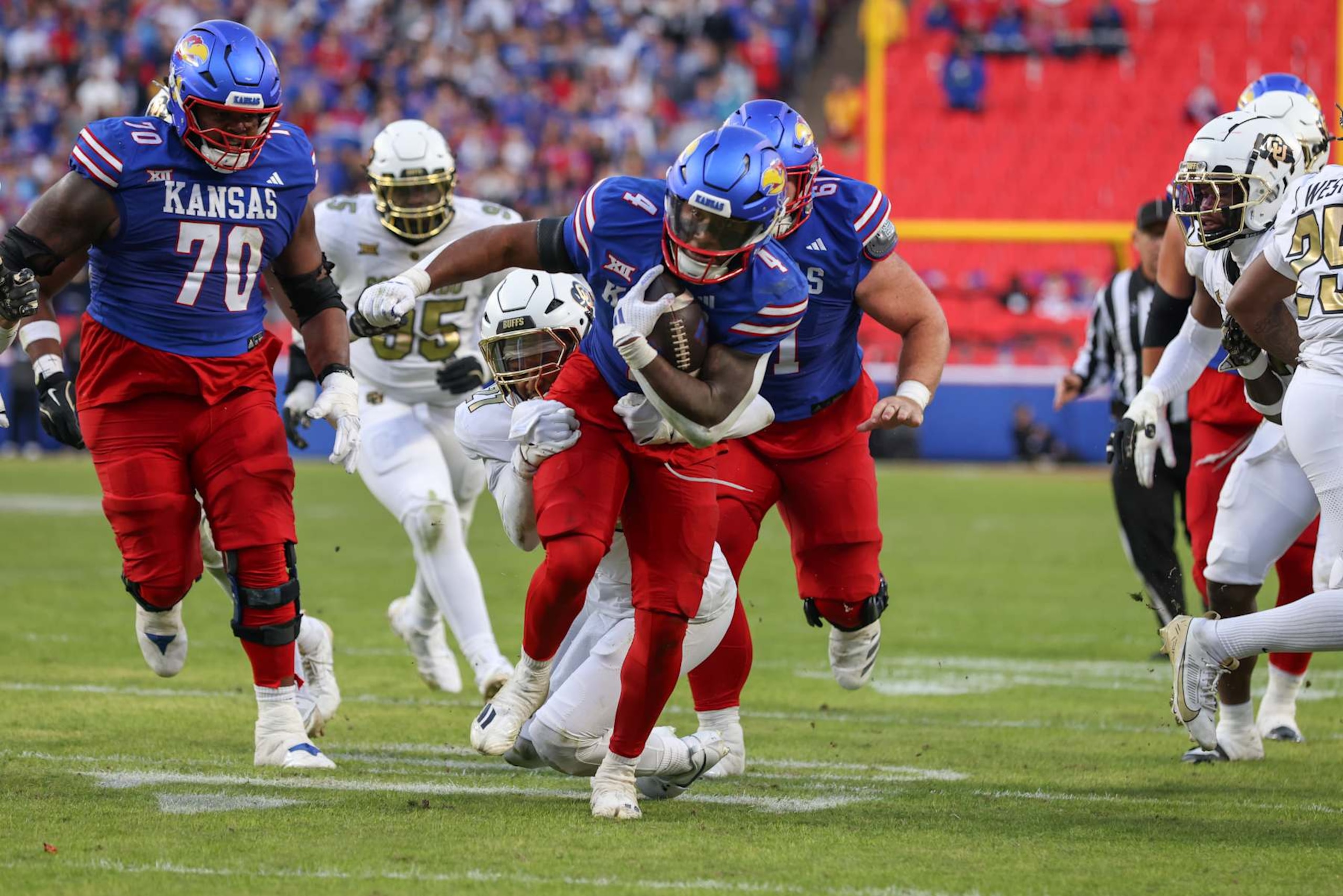 KANSAS CITY, MO - NOVEMBER 23: Kansas Jayhawks running back Devin Neal (4) breaks a tackle on a run in the second quarter of a Big 12 game between the Colorado Buffaloes and Kansas Jayhawks on November 23, 2024 at GEHA Field at Arrowhead Stadium in Kansas City, MO. (Photo by Scott Winters/Icon Sportswire via Getty Images)