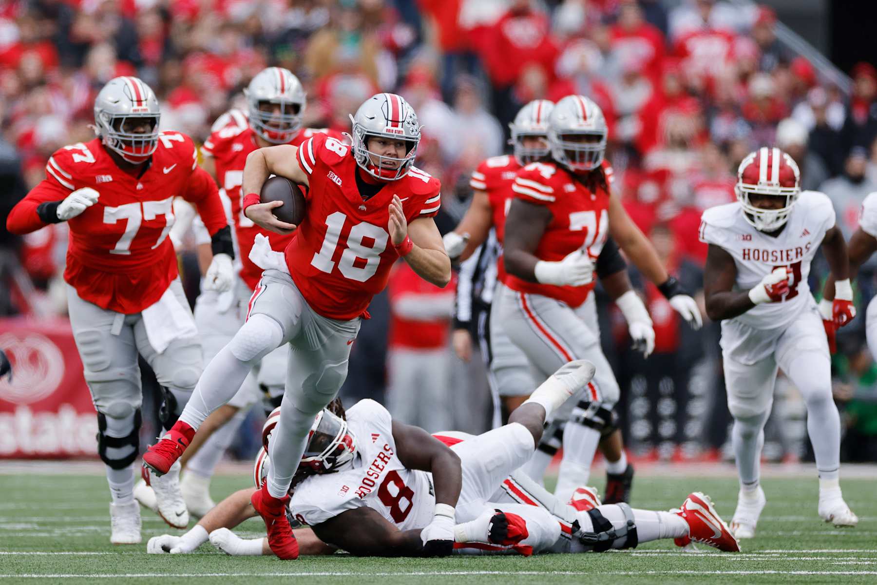 COLUMBUS, OH - NOVEMBER 23: Ohio State Buckeyes quarterback Will Howard (18) slips out of a tackle attempt by Indiana Hoosiers defensive lineman CJ West (8) during a college football game on November 23, 2024 at Ohio Stadium in Columbus, Ohio. (Photo by Joe Robbins/Icon Sportswire via Getty Images)