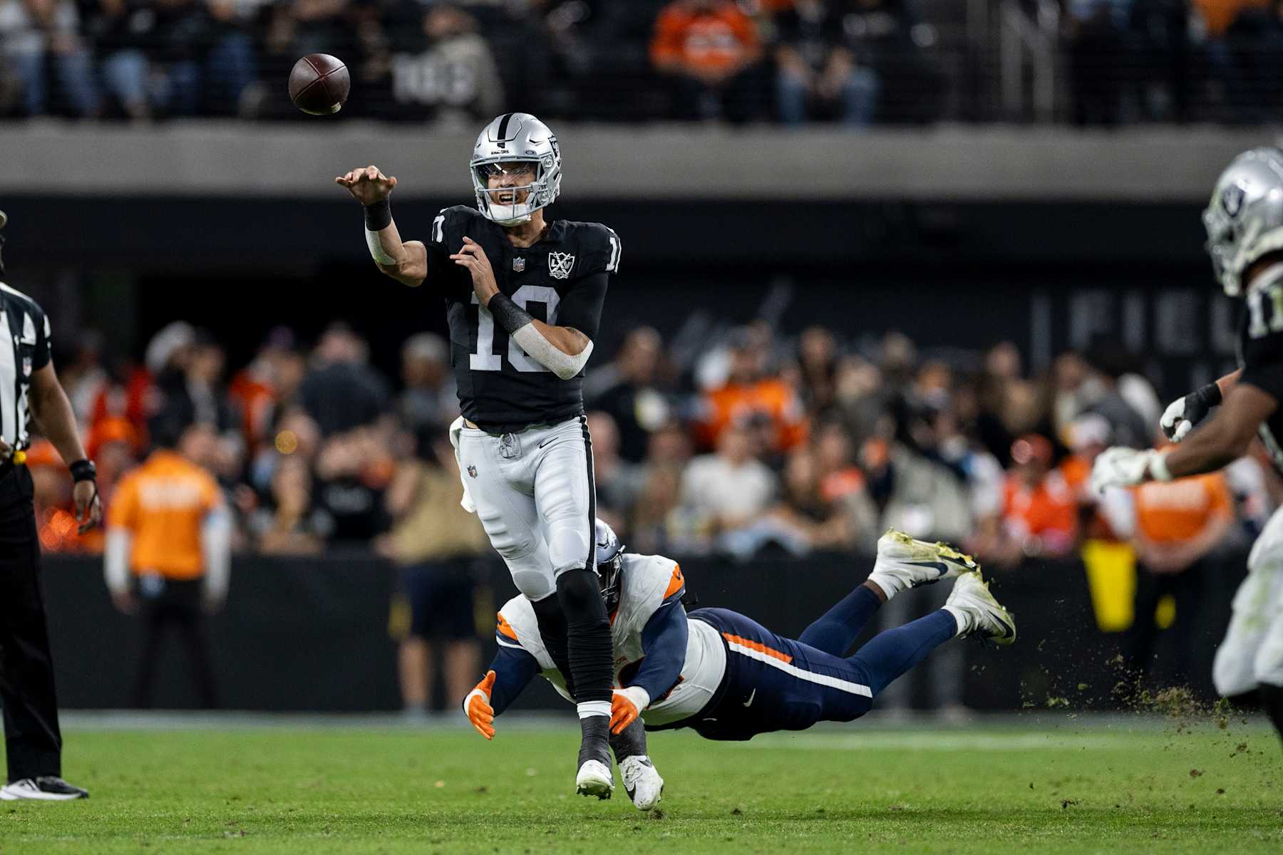 LAS VEGAS, NEVADA - NOVEMBER 24: Desmond Ridder #10 of the Las Vegas Raiders throws a pass on the run as he's tackled by Dondrea Tillman #92 of the Denver Broncos during an NFL Football game at Allegiant Stadium on November 24, 2024 in Las Vegas, Nevada. (Photo by Michael Owens/Getty Images) LAS VEGAS, NEVADA - NOVEMBER 24: Desmond Ridder #10 of the Las Vegas Raiders throws a pass on the run as he's tackled by Dondrea Tillman #92 of the Denver Broncos during an NFL Football game at Allegiant Stadium on November 24, 2024 in Las Vegas, Nevada. (Photo by Michael Owens/Getty Images)