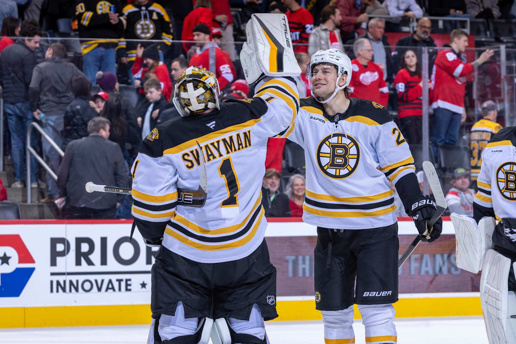 DETROIT, MICHIGAN-NOVEMBER 23: Jeremy Swayman #1 of the Boston Bruins celebrates the win with Brandon Carlo #25 after the game against the Detroit Red Wings at Little Caesars Arena on November 23, 2024 in Detroit, Michigan. Boston defeated Detroit 2-1. (Photo by Dave Reginek/NHLI via Getty Images)