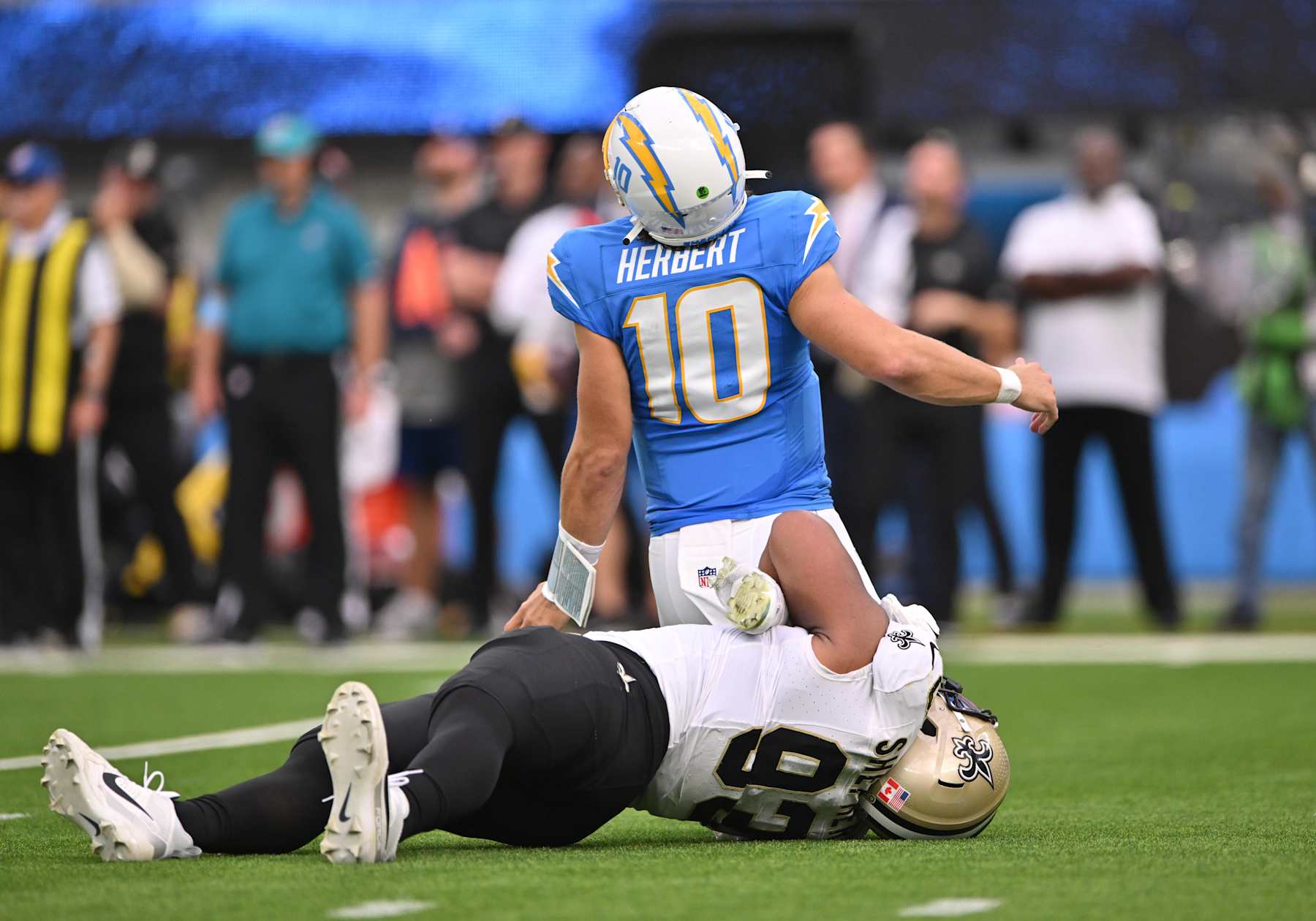 INGLEWOOD, CA - OCTOBER 27: New Orleans Saints defensive tackle Nathan Shepherd (93) rolls up on Los Angeles Chargers quarterback Justin Herbert (10) ankles during the game between the Saints and the Chargers on October 27, 2024, at SoFi Stadium in Inglewood, CA. (Photo by David Dennis/Icon Sportswire via Getty Images)