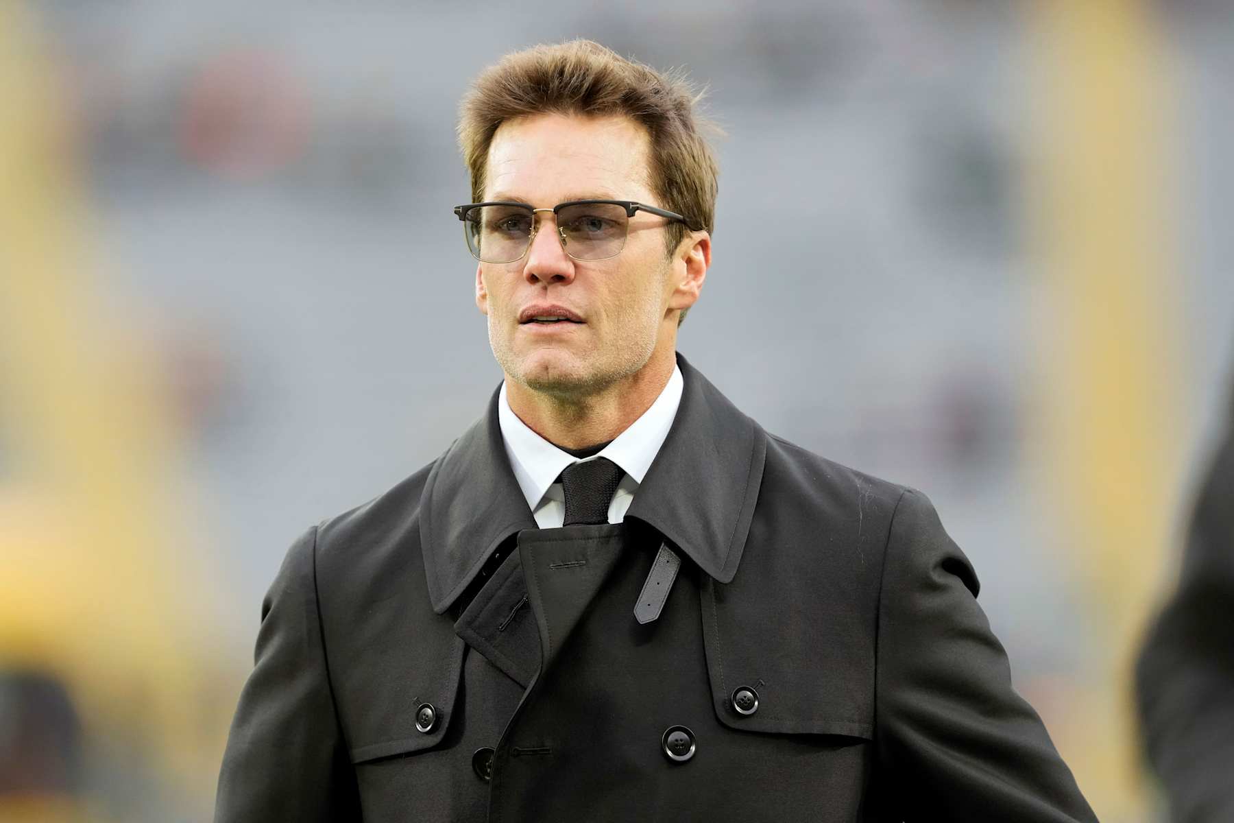 GREEN BAY, WISCONSIN - NOVEMBER 24: Tom Brady walks across the field before the game between the San Francisco 49ers and the Green Bay Packers at Lambeau Field on November 24, 2024 in Green Bay, Wisconsin. (Photo by Patrick McDermott/Getty Images)