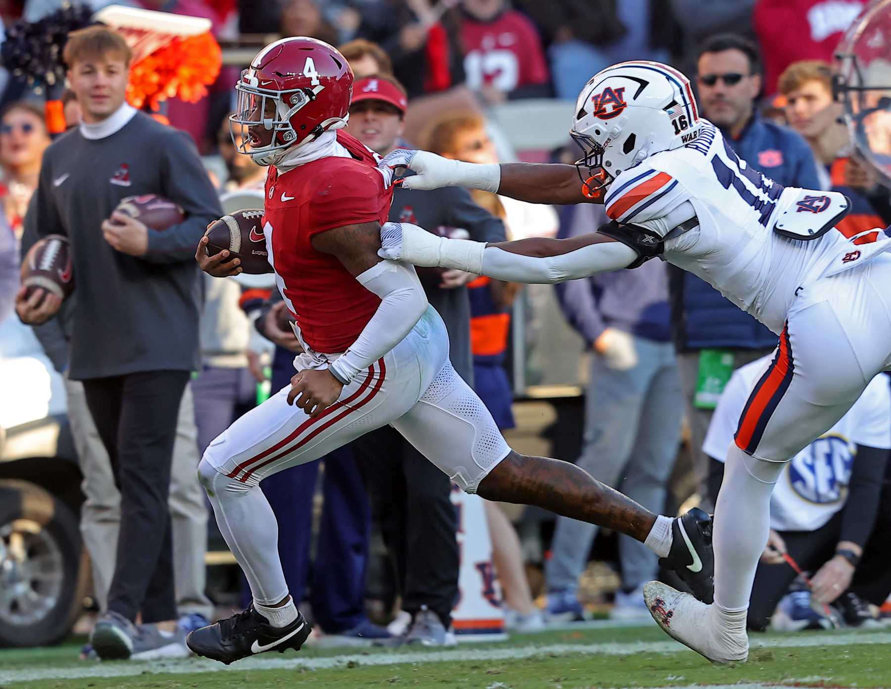 TUSCALOOSA, ALABAMA - NOVEMBER 30: Jalen Milroe #4 of the Alabama Crimson Tide breaks a tackle by Demarcus Riddick #16 of the Auburn Tigers as Milroe rushes for a touchdown during the first half at Bryant-Denny Stadium on November 30, 2024 in Tuscaloosa, Alabama. (Photo by Jason Clark/Getty Images)