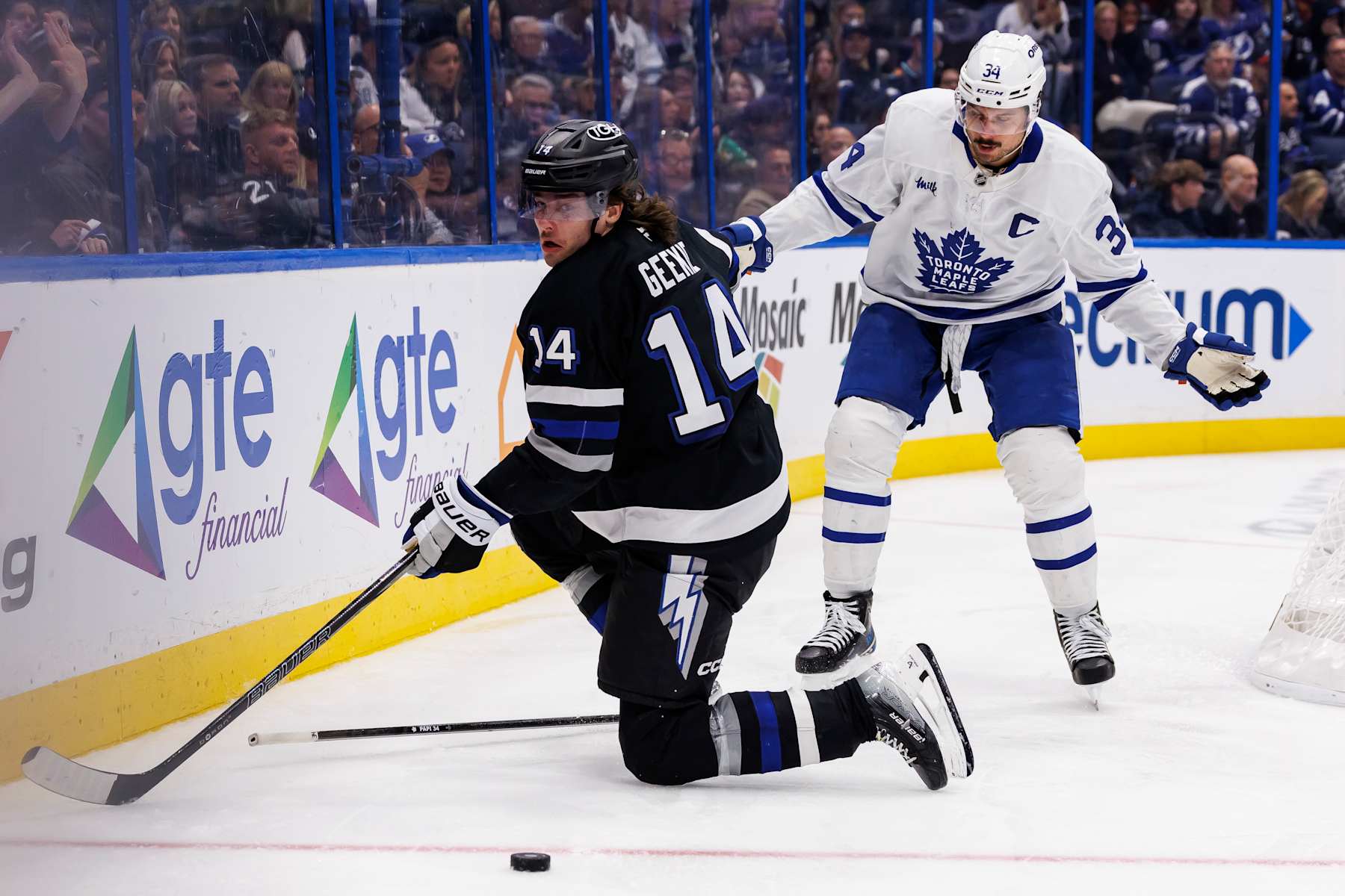 TAMPA, FL - NOVEMBER 30: Conor Geekie #14 of the Tampa Bay Lightning skates against Auston Matthews #34 of the Toronto Maple Leafs at Amalie Arena on November 30, 2024 in Tampa, Florida. (Photo by Mark LoMoglio/NHLI via Getty Images)
