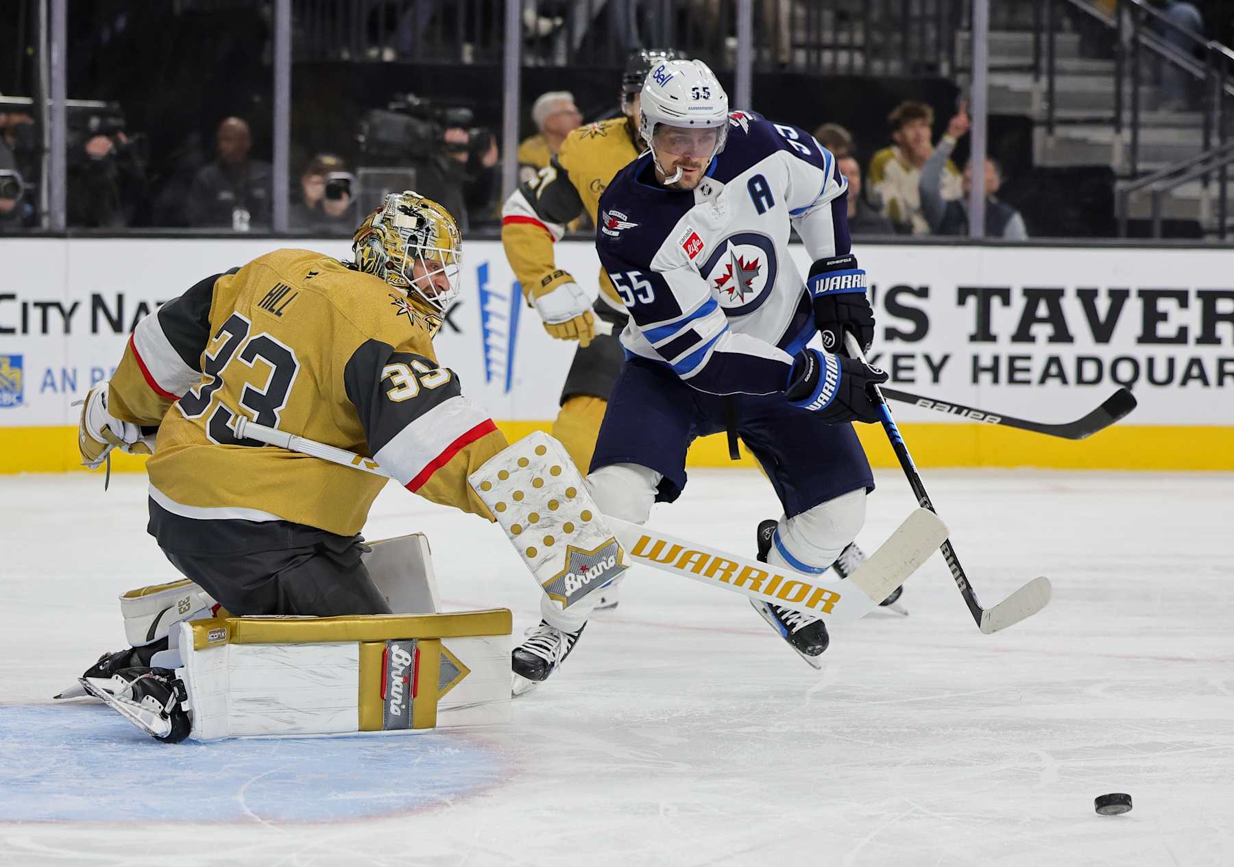LAS VEGAS, NEVADA - NOVEMBER 29: Adin Hill #33 of the Vegas Golden Knights makes a save as Mark Scheifele #55 of the Winnipeg Jets looks for a rebound in the first period of their game at T-Mobile Arena on November 29, 2024 in Las Vegas, Nevada. The Golden Knights defeated the Jets 4-3. (Photo by Ethan Miller/Getty Images)