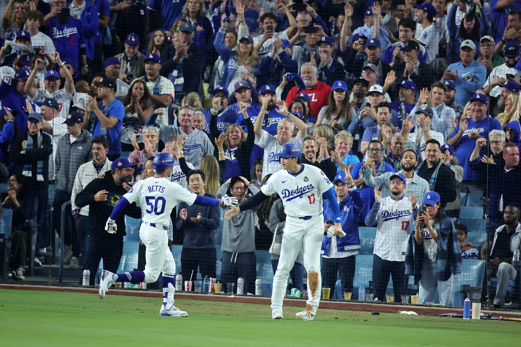 LOS ANGELES, CALIFORNIA - OCTOBER 25: Mookie Betts #50 and Shohei Ohtani #17 of the Los Angeles Dodgers react after Ohtani scored a run on Betts' sacrifice fly in the eighth inning against the New York Yankees during Game One of the 2024 World Series at Dodger Stadium on October 25, 2024 in Los Angeles, California. (Photo by Alex Slitz/Getty Images)