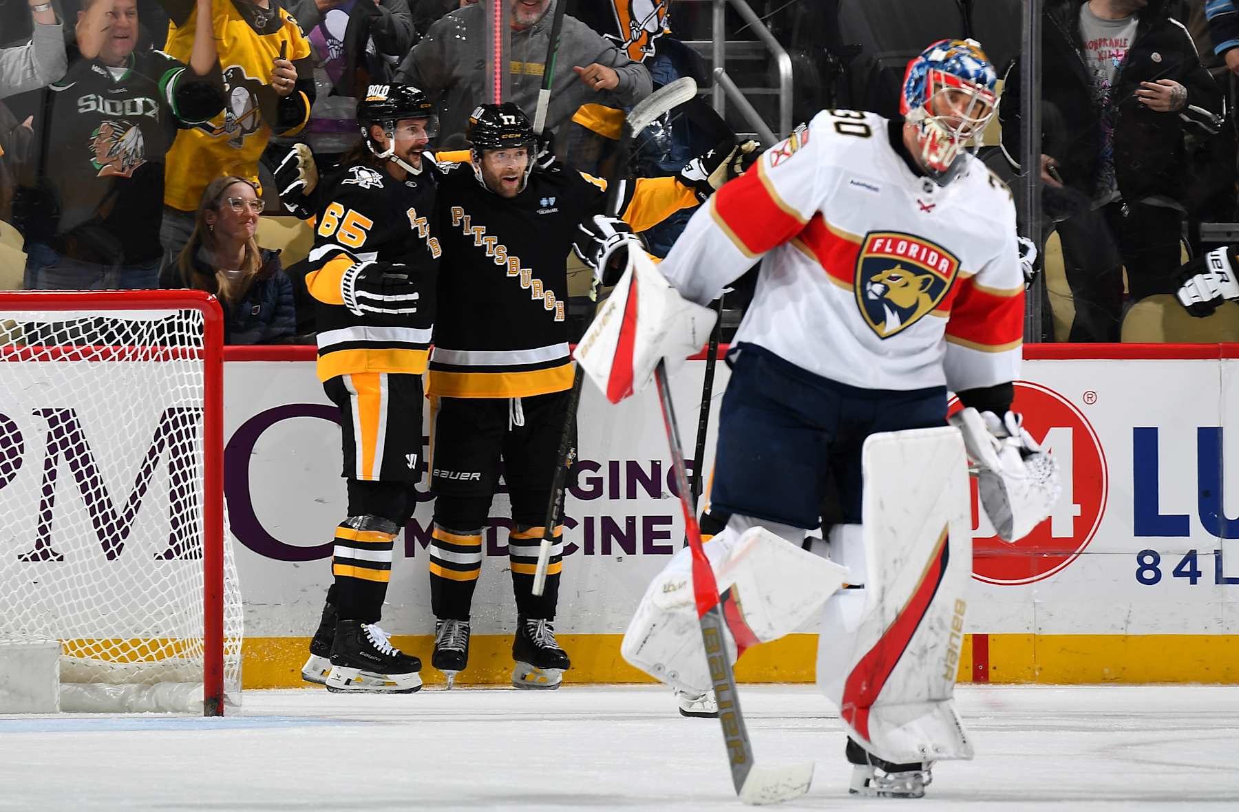PITTSBURGH, PA - DECEMBER 03: Bryan Rust #17 celebrates his overtime goal with Erik Karlsson #65 of the Pittsburgh Penguins in front of Spencer Knight #30 of the Florida Panthers at PPG PAINTS Arena on December 3, 2024 in Pittsburgh, Pennsylvania. (Photo by Joe Sargent/NHLI via Getty Images)