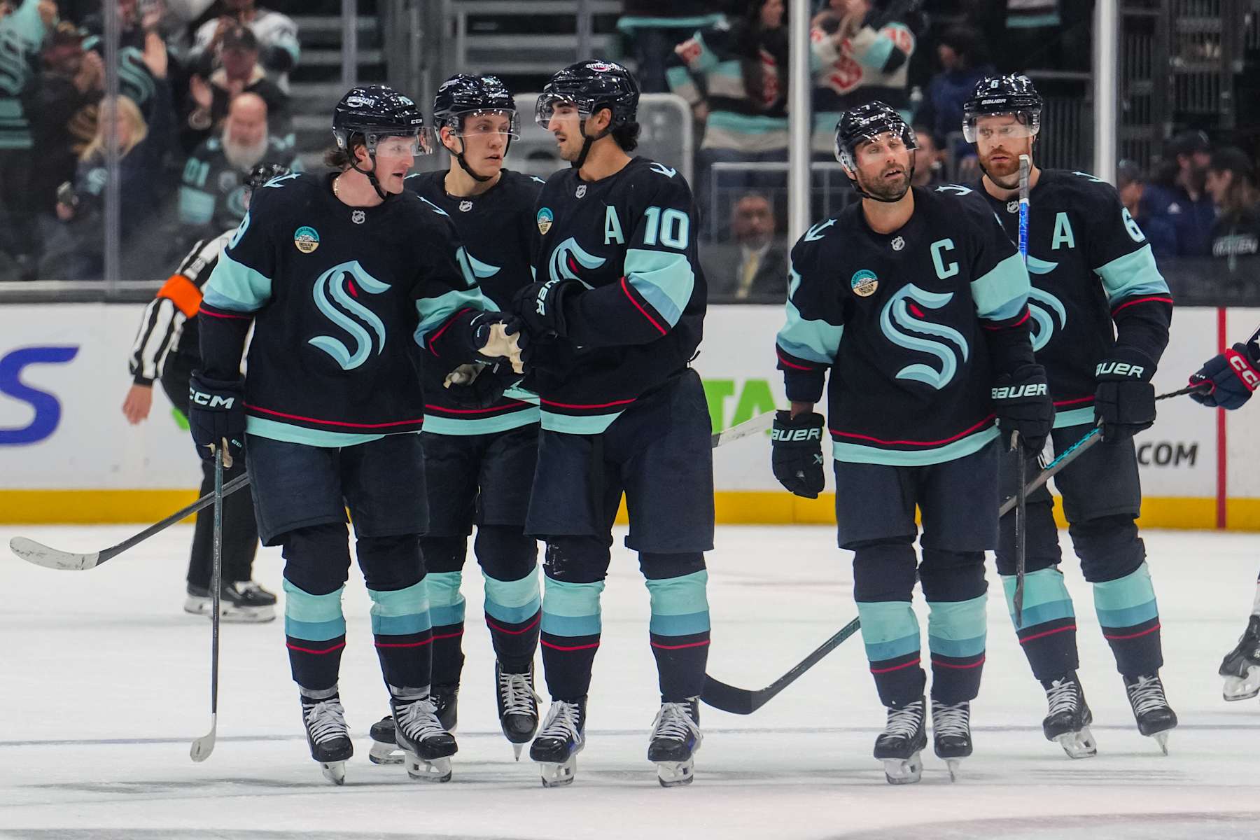 SEATTLE, WASHINGTON - NOVEMBER 12: Jared McCann #19 of the Seattle Kraken celebrates with teammates after scoring a goal during the third period of a game against the Columbus Blue Jackets at Climate Pledge Arena on November 12, 2024 in Seattle, Washington. (Photo by Christopher Mast/NHLI via Getty Images)
