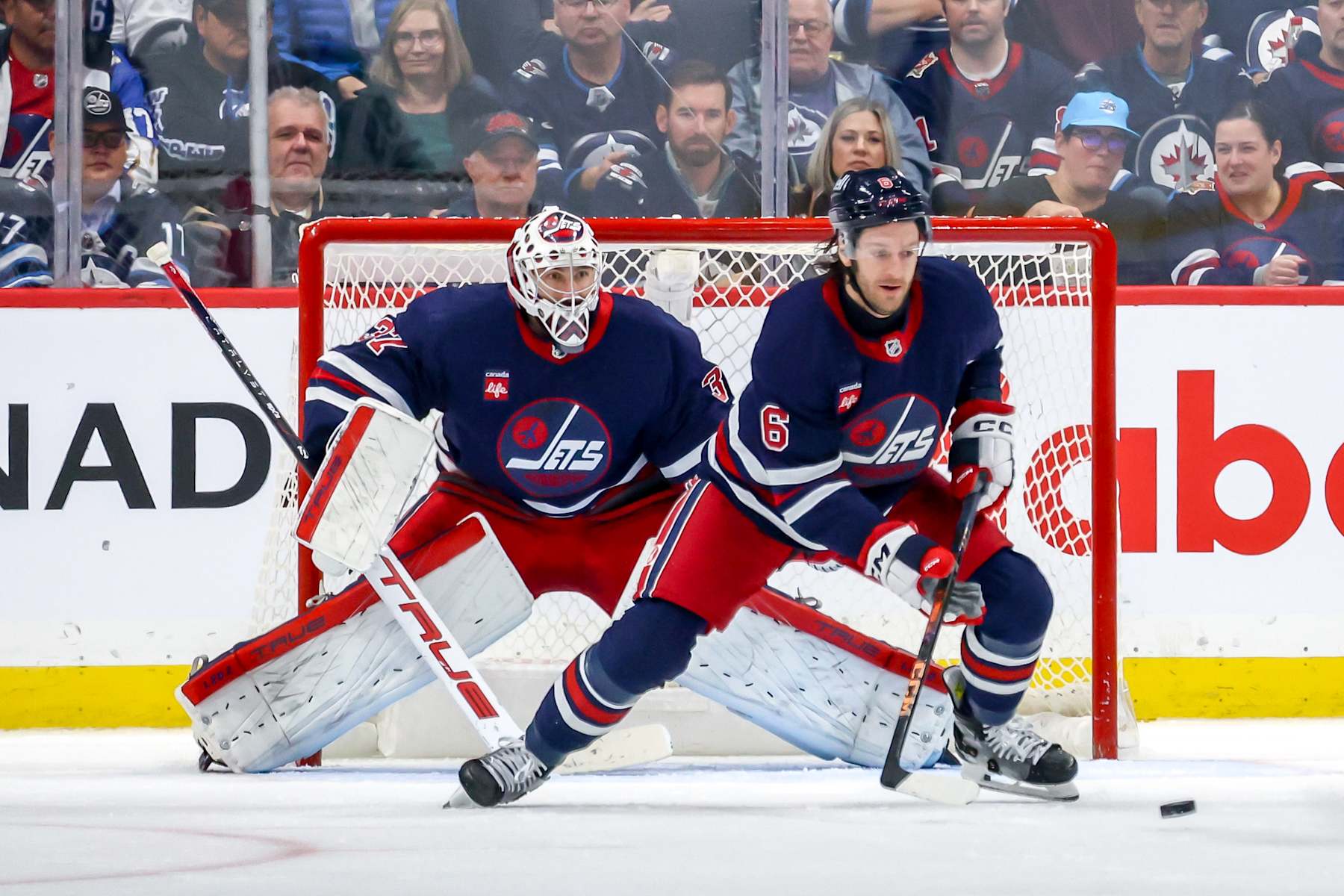 WINNIPEG, CANADA - NOVEMBER 9: Goaltender Connor Hellebuyck #37 and Colin Miller #6 of the Winnipeg Jets guard the net during second period action against the Dallas Stars at the Canada Life Centre on November 9, 2024 in Winnipeg, Manitoba, Canada. (Photo by Jonathan Kozub/NHLI via Getty Images)