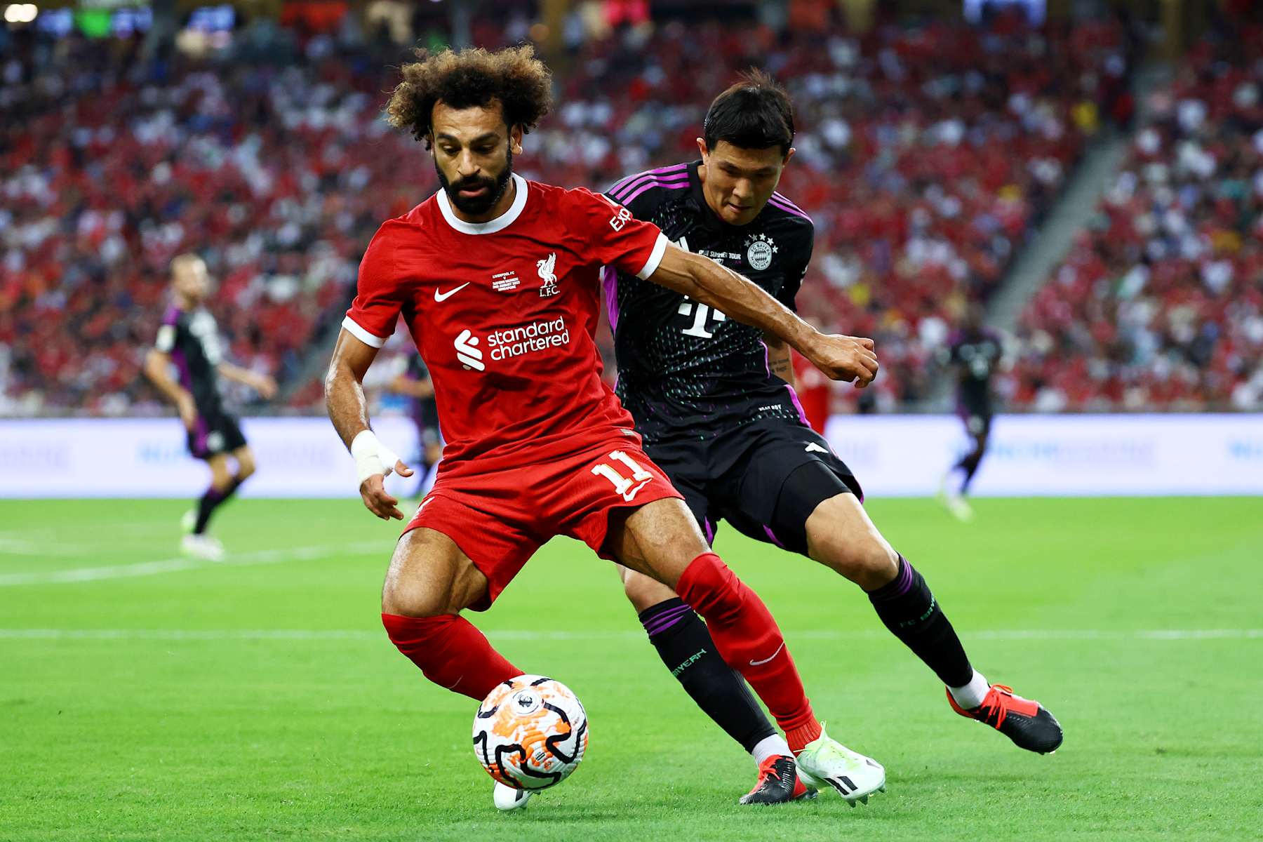 SINGAPORE, SINGAPORE - AUGUST 02: Mohamed Salah #11 of Liverpool controls the ball against Minjae Kim #3 of Bayern Munich during the first half of the pre-season friendly at the National Stadium on August 02, 2023 in Singapore. (Photo by Yong Teck Lim/Getty Images)