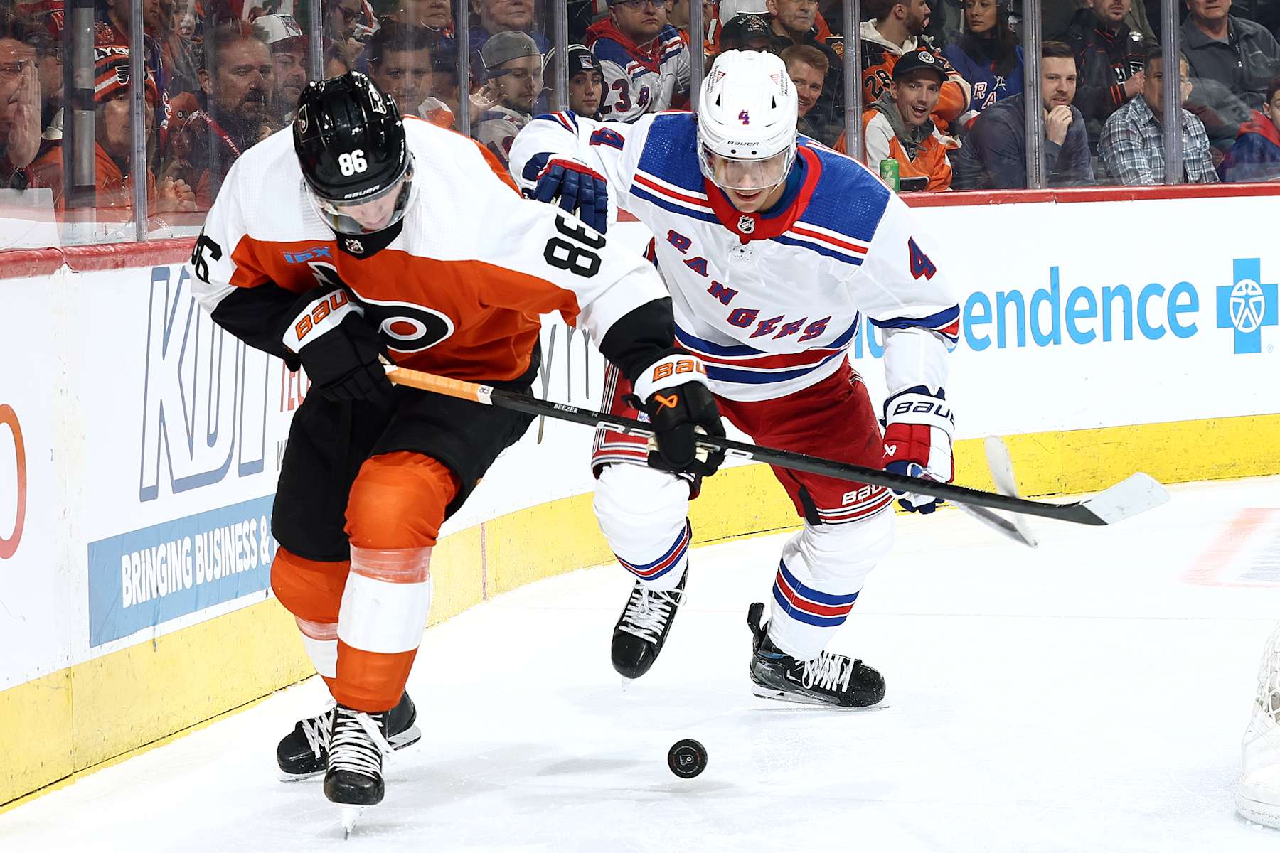 PHILADELPHIA, PENNSYLVANIA - FEBRUARY 24: Joel Farabee #86 of the Philadelphia Flyers and Braden Schneider #4 of the New York Rangers challenge for the puck during the second period at the Wells Fargo Center on February 24, 2024 in Philadelphia, Pennsylvania. (Photo by Tim Nwachukwu/Getty Images)