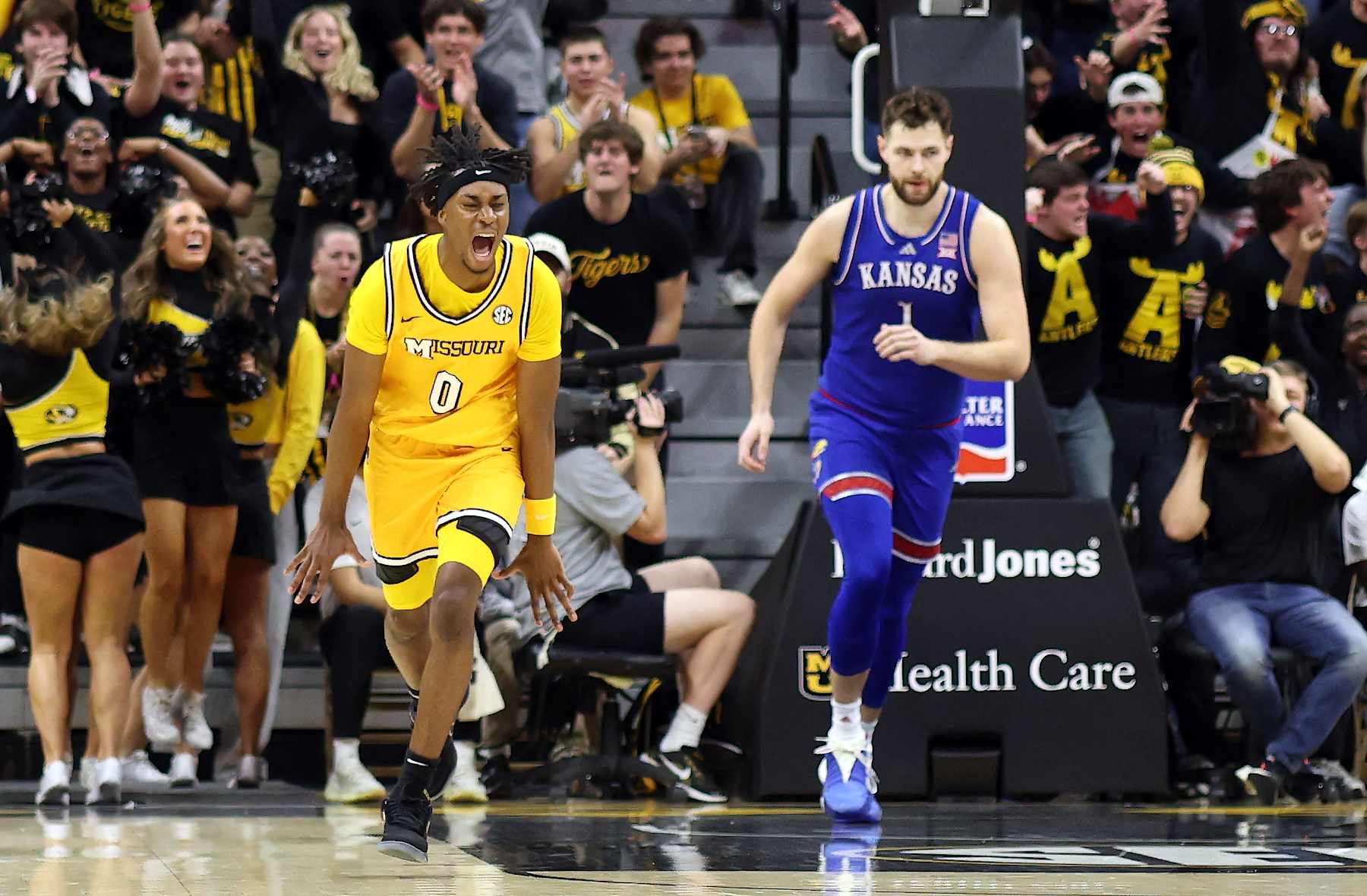 COLUMBIA, MISSOURI - DECEMBER 08:  Anthony Robinson II #0 of the Missouri Tigers reacts after scoring on a fast break as Hunter Dickinson #1 of the Kansas Jayhawks defends during the first half of the game at Mizzou Arena on December 08, 2024 in Columbia, Missouri. (Photo by Jamie Squire/Getty Images)