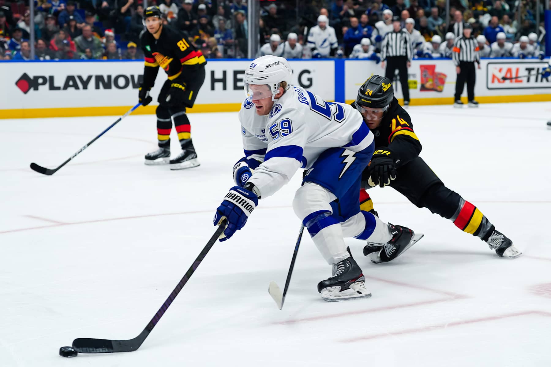 VANCOUVER, CANADA - DECEMBER 8: Jake Guentzel #59 of the Tampa Bay Lightning is checked by Pius Suter #24 of the Vancouver Canucks during the second period of their NHL game at Rogers Arena on December 8, 2024 in Vancouver, British Columbia, Canada. (Photo by Derek Cain/Getty Images)