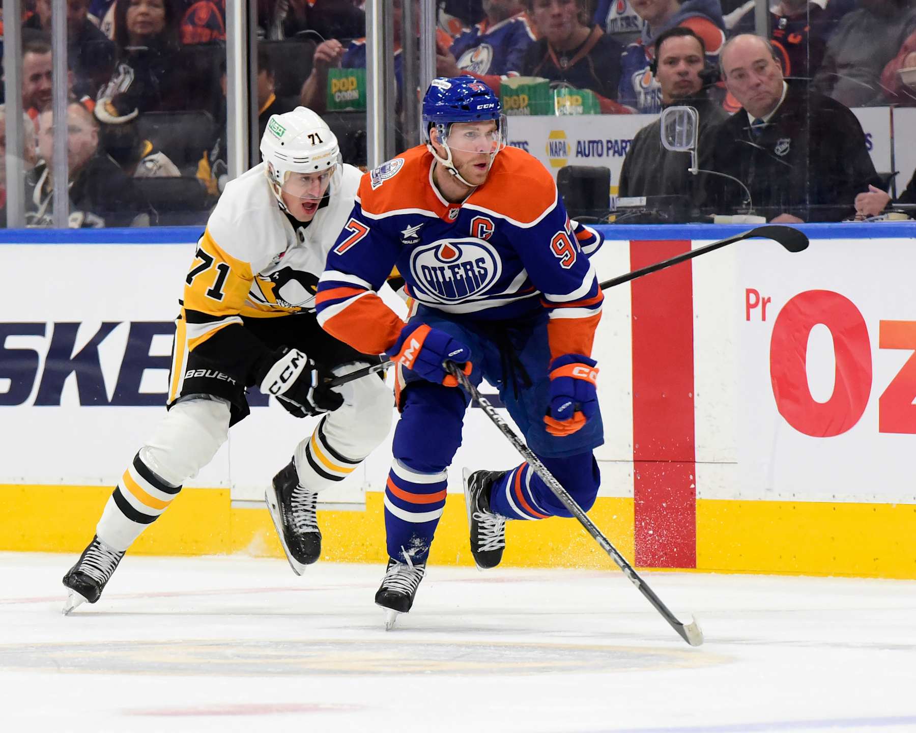 Edmonton Oilers captain Connor McDavid being pursued by Pittsburgh Penguins center Evgeni Malkin.