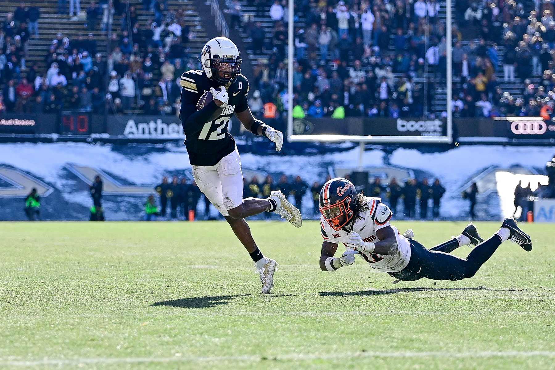 BOULDER, CO - NOVEMBER 29:  Travis Hunter #12 of the Colorado Buffaloes runs away from a tackle attempt by Dylan Smith #11 of the Oklahoma State Cowboys after a catch in the third quarter at Folsom Field on November 29, 2024 in Boulder, Colorado. (Photo by Dustin Bradford/Getty Images)