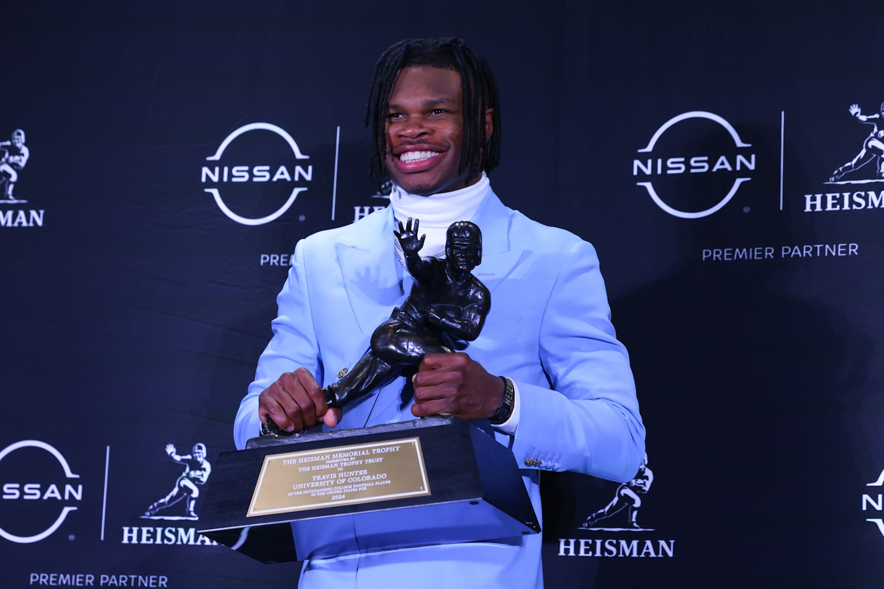 NEW YORK, NY - DECEMBER 14:  Travis Hunter University of Colorado cornerback/wide receiver poses with the Trophy during the Heisman Trophy press conference at the Marriott Marquis on December 14, 2024 in New York, New York. (Photo by Rich Graessle/Icon Sportswire via Getty Images)
