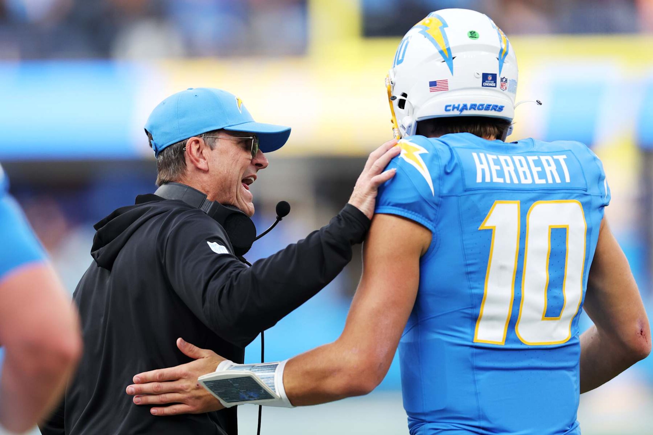 INGLEWOOD, CALIFORNIA - DECEMBER 15: Head coach Jim Harbaugh celebrates with Justin Herbert #10 of the Los Angeles Chargers after a touchdown in the first quarter against the Tampa Bay Buccaneers at SoFi Stadium on December 15, 2024 in Inglewood, California. (Photo by Harry How/Getty Images)