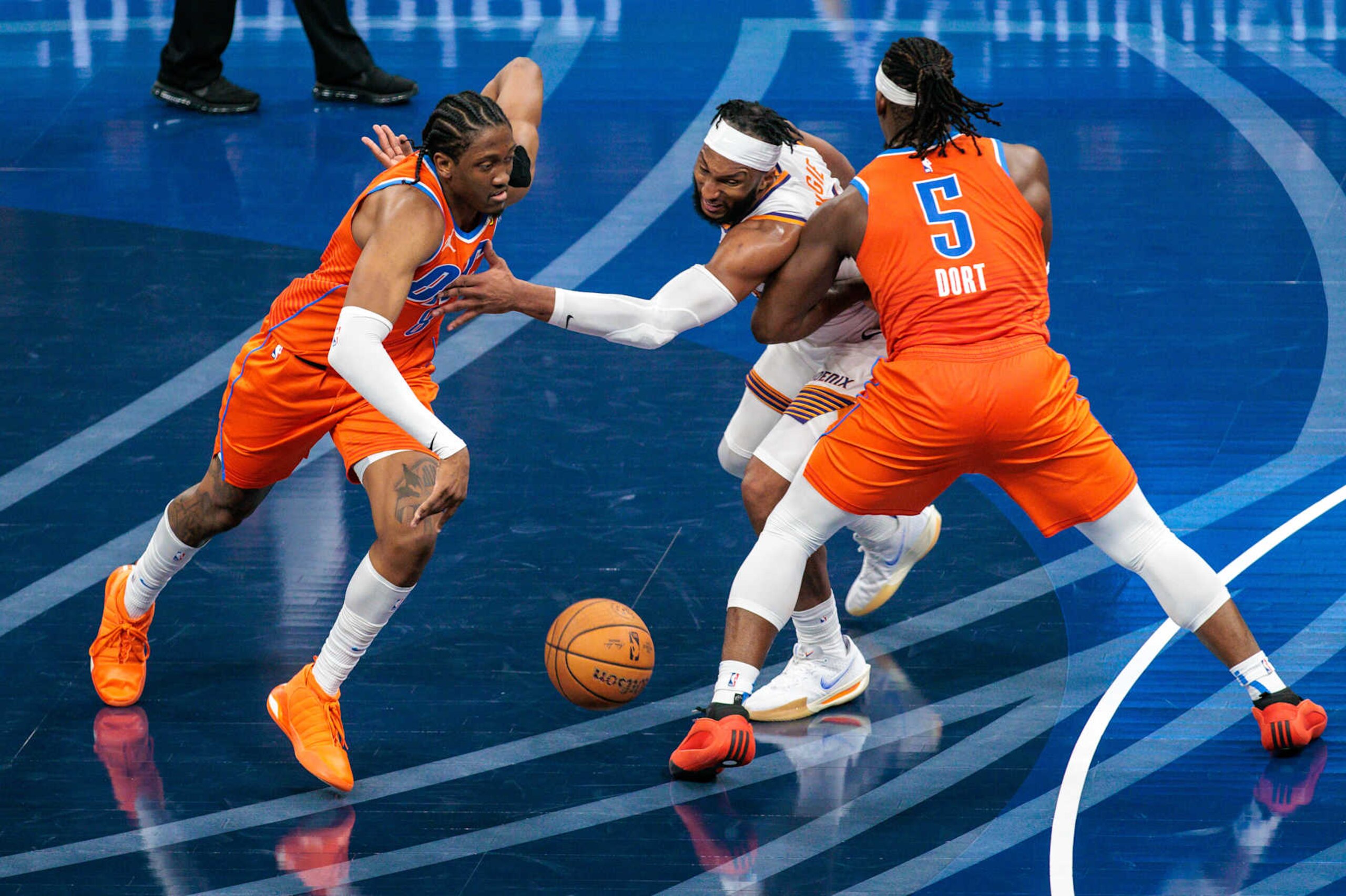 OKLAHOMA CITY, OKLAHOMA - NOVEMBER 15: Jalen Williams #8 of the Oklahoma City Thunder drives around Josh Okogie #2 of the Phoenix Suns being guarded by Luguentz Dort #5 of the Oklahoma City Thunder during the third quarter of the Emirates NBA Cup game at Paycom Center on November 15, 2024 in Oklahoma City, Oklahoma. NOTE TO USER: User expressly acknowledges and agrees that, by downloading and or using this photograph, User is consenting to the terms and conditions of the Getty Images License Agreement. (Photo by William Purnell/Getty Images)
