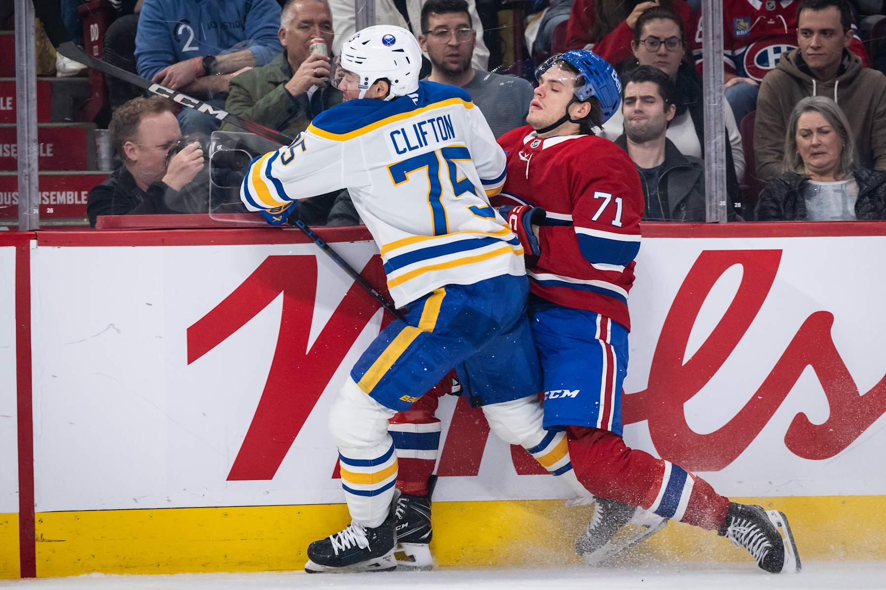 MONTREAL, QC - DECEMBER 17: Connor Clifton (75) of the Buffalo Sabres checks Jake Evans (71) of the Montreal Canadiens into the boards during the third period of the NHL game between the Buffalo Sabres and the Montreal Canadiens on Dec 17 2024, at the Bell Centre in Montreal, QC(Photo by Vincent Ethier/Icon Sportswire via Getty Images)