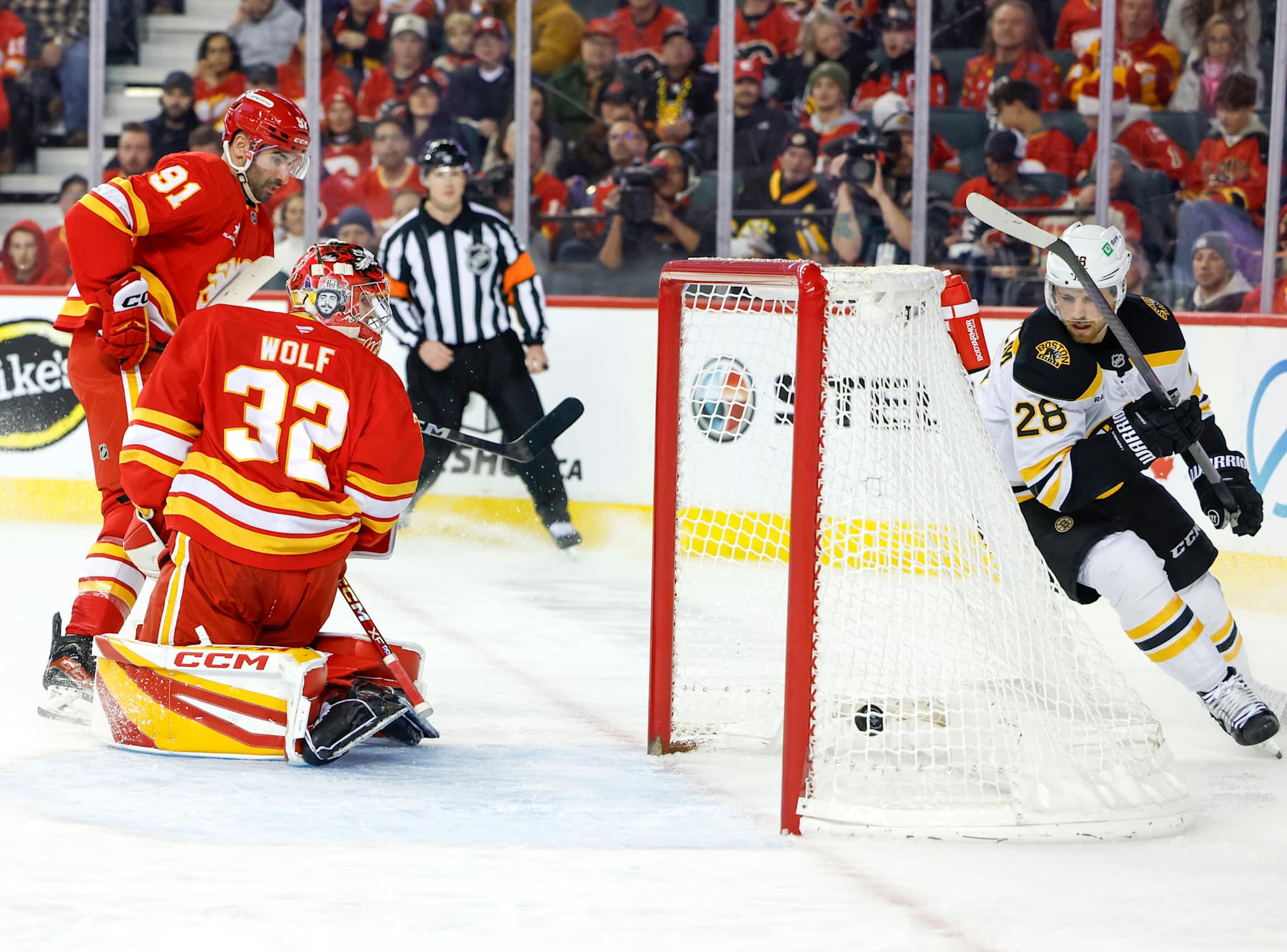 CALGARY, CANADA - DECEMBER 17: Elias Lindholm #28 of the Boston Bruins scores on Dustin Wolf #32 of the Calgary Flames on a wrap-around goal during the second period at the Scotiabank Saddledome on December 17, 2024, in Calgary, Alberta, Canada. (Photo by Leah Hennel/Getty Images)