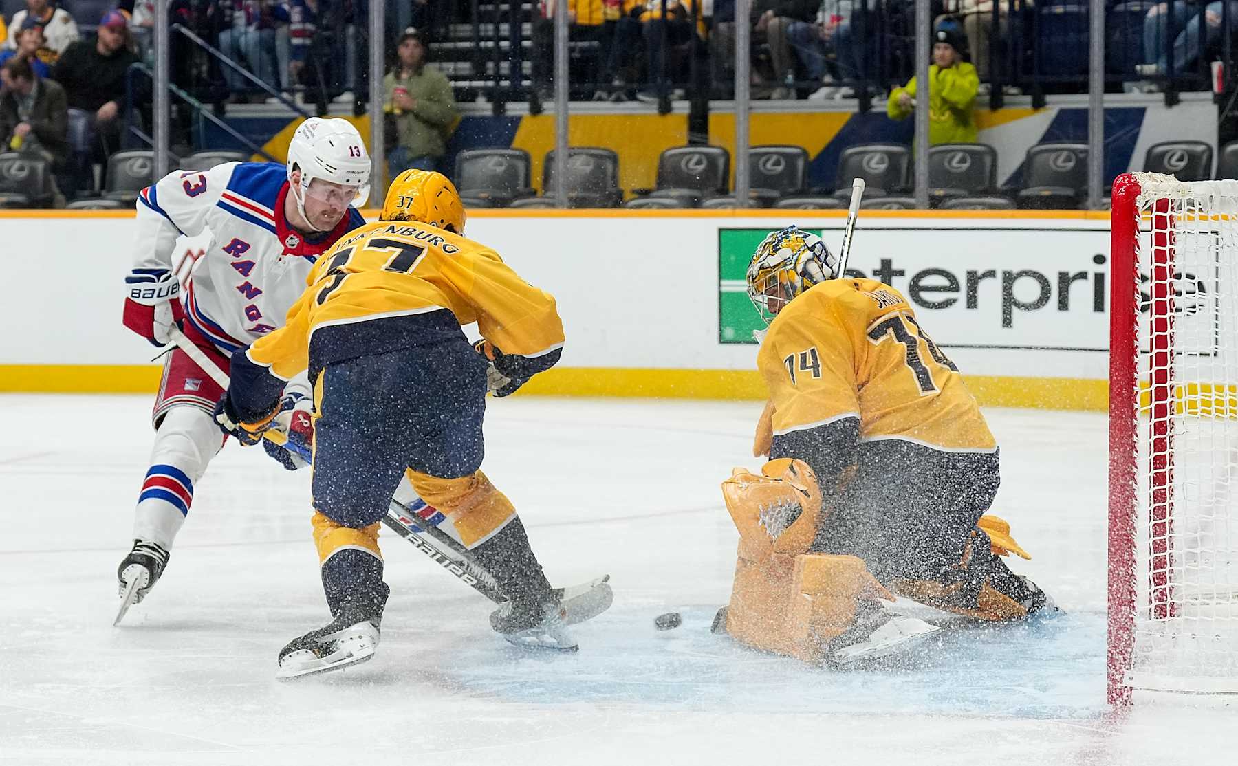 NASHVILLE, TENNESSEE - DECEMBER 17: Juuse Saros #74 of the Nashville Predators makes a save against Alexis Lafrenière #13 of the New York Rangers during an NHL game at Bridgestone Arena on December 17, 2024 in Nashville, Tennessee. (Photo by John Russell/NHLI via Getty Images)