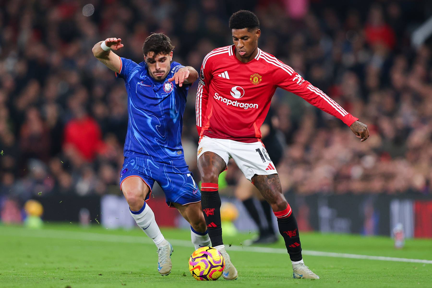 MANCHESTER, ENGLAND - NOVEMBER 03: Marcus Rashford of Manchester United battles for possession with Pedro Neto of Chelsea during the Premier League match between Manchester United FC and Chelsea FC at Old Trafford on November 03, 2024 in Manchester, England. (Photo by James Gill - Danehouse/Getty Images)